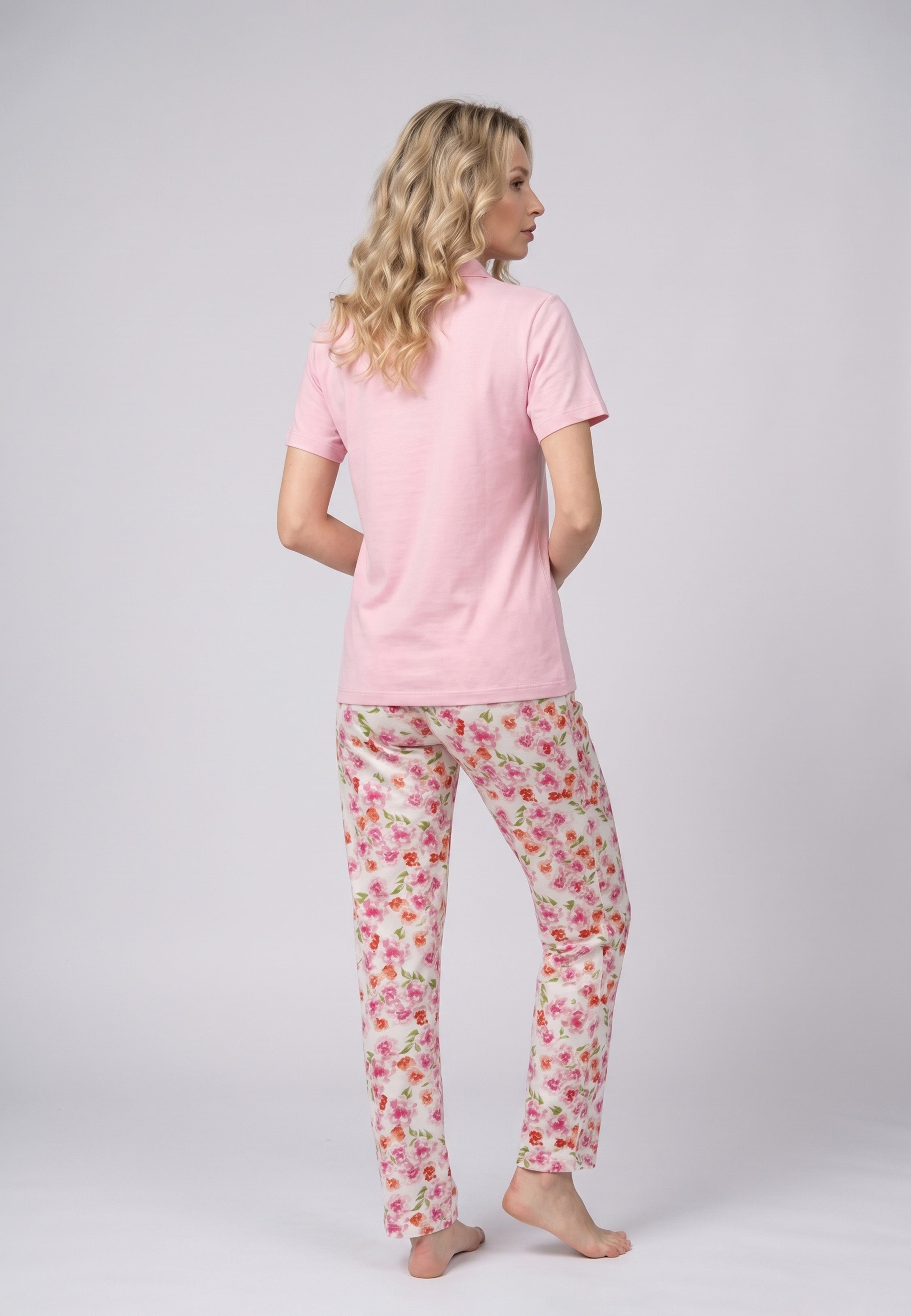 Femme portant un pyjama deux pièces top col claudine fuchsia uni et pantalon long imprimé aquarelle fuchsia et blanc Rosabella Mellow Moments