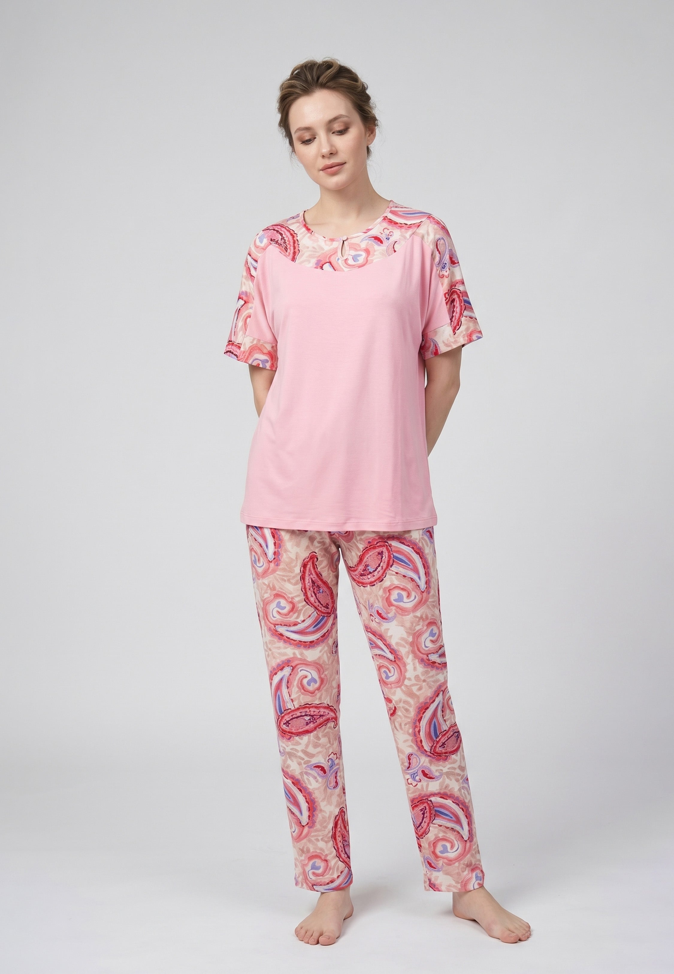 Femme portant un pyjama deux pièces t-shirt col rond uni rose empiècement imprimé paisley et pantalon droit imprimé paisley multicolore rose et rouge Rosabella Ethnique 2