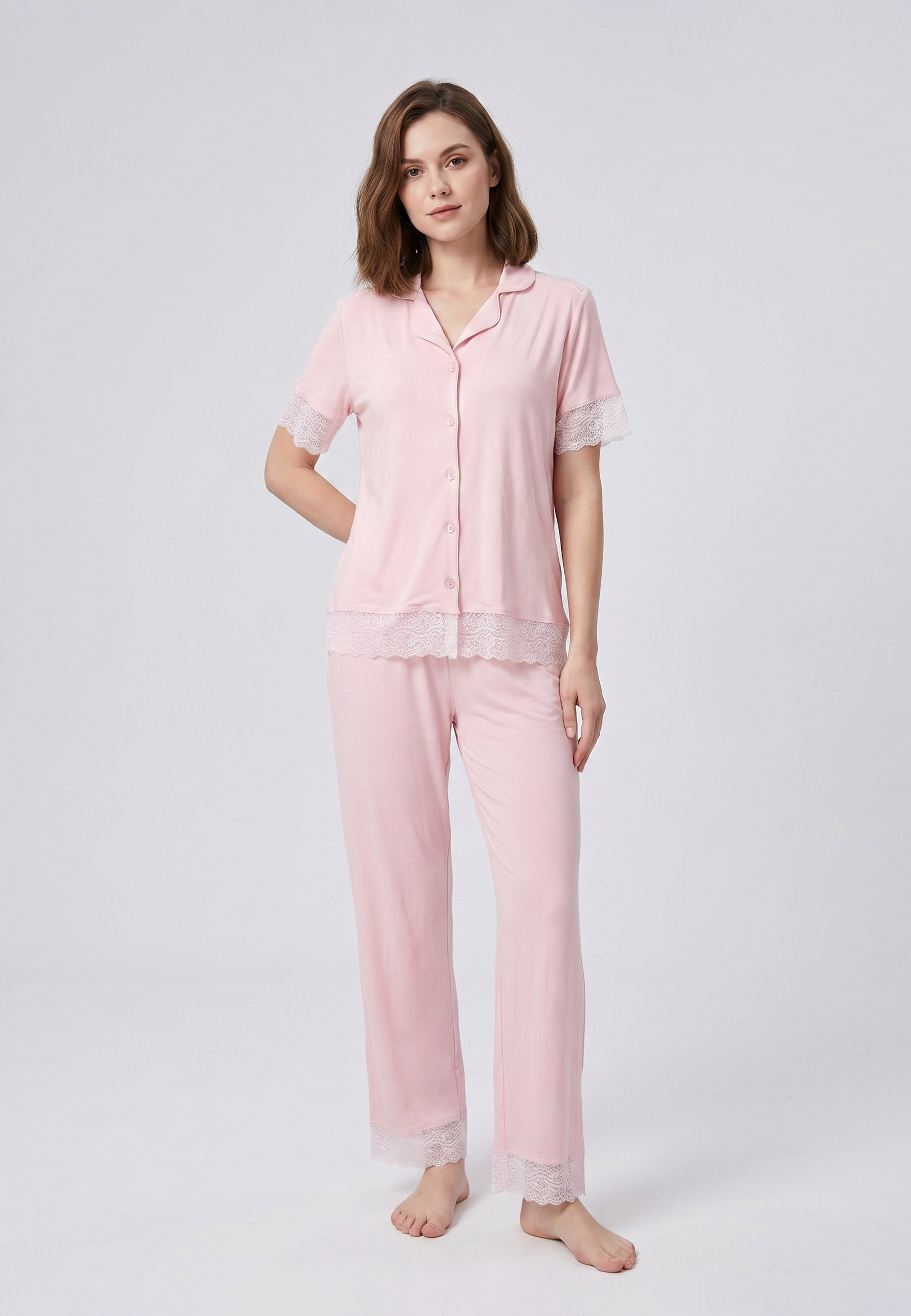 Femme portant un pyjama deux pièces chemise boutonnée unie dentelle rose clair et pantalon long uni dentelle aux chevilles Rosabella Chic Line