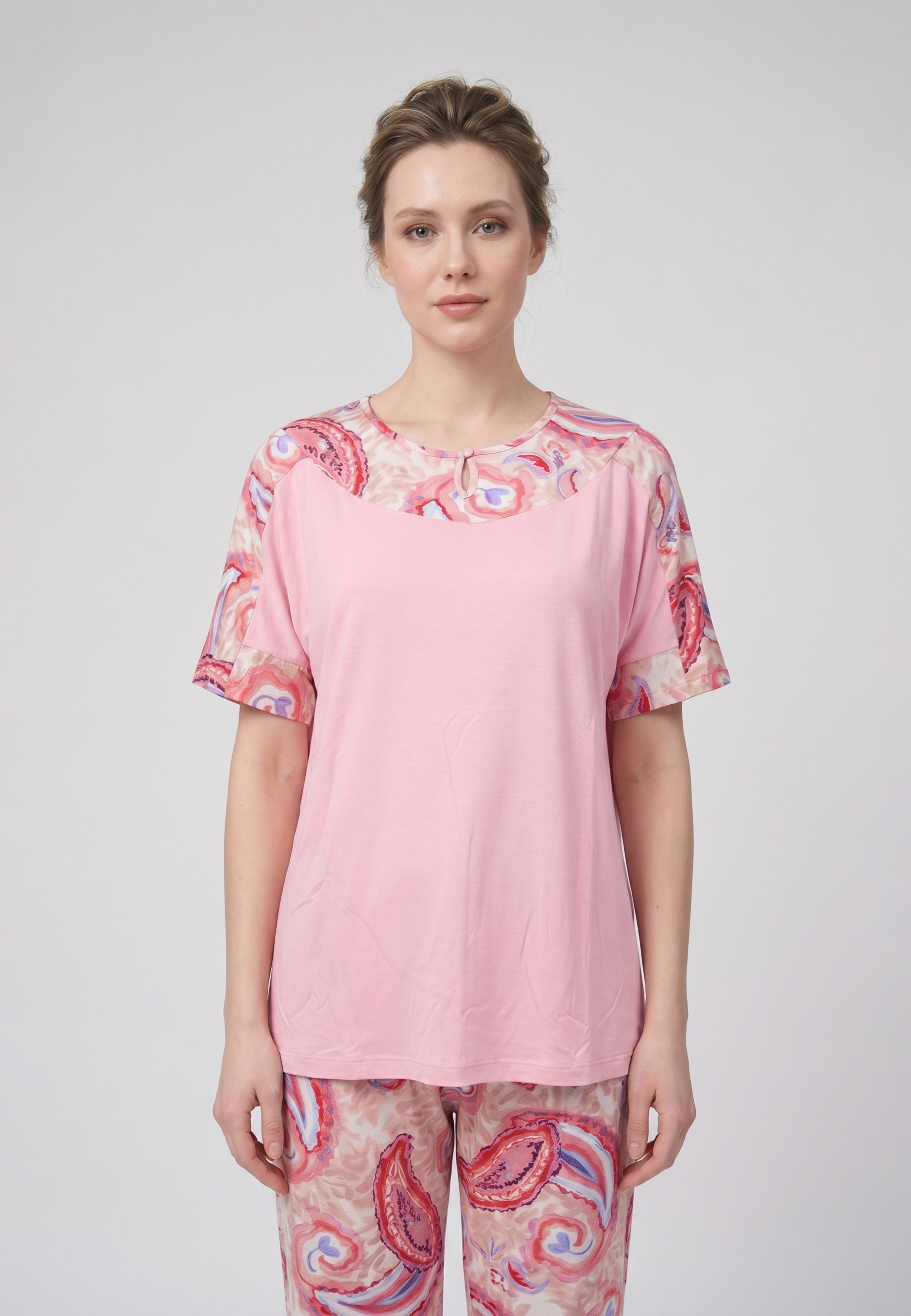 Femme portant un pyjama deux pièces t-shirt col rond uni rose empiècement imprimé paisley et pantalon droit imprimé paisley multicolore rose et rouge Rosabella Ethnique 2