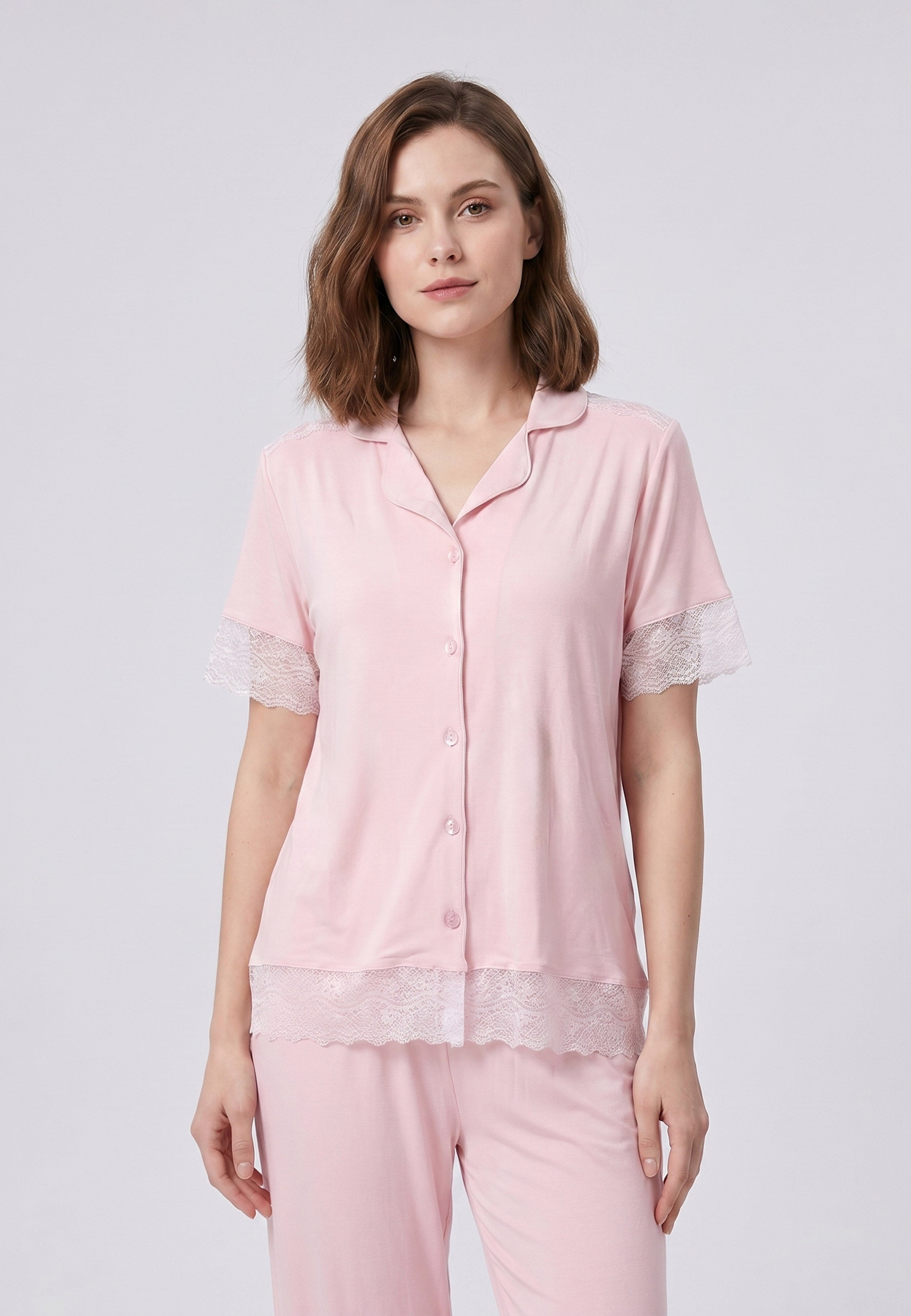 Femme portant un pyjama deux pièces chemise boutonnée unie dentelle rose clair et pantalon long uni dentelle aux chevilles Rosabella Chic Line