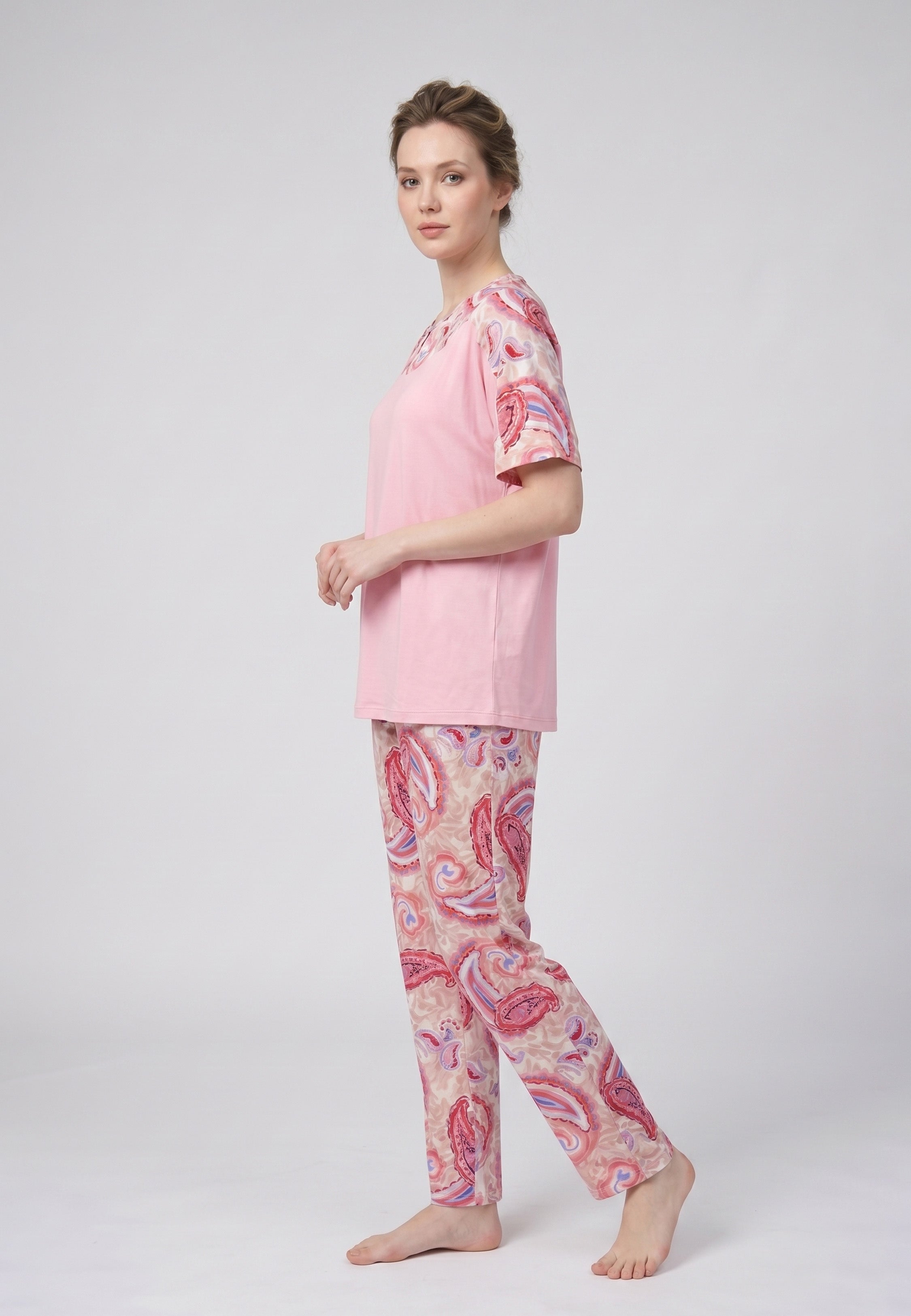 Femme portant un pyjama deux pièces t-shirt col rond uni rose empiècement imprimé paisley et pantalon droit imprimé paisley multicolore rose et rouge Rosabella Ethnique 2