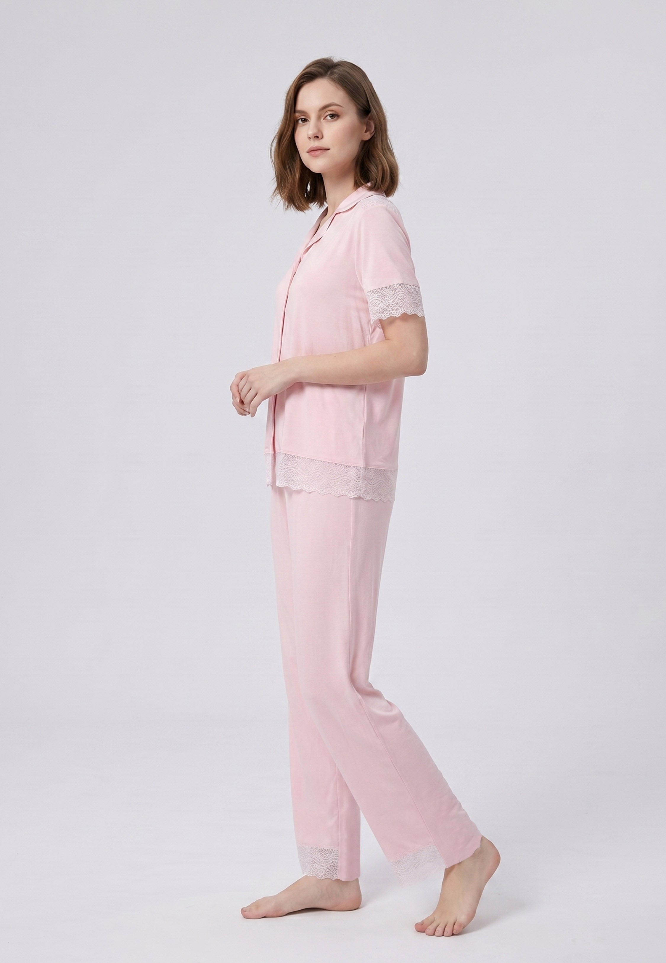 Femme portant un pyjama deux pièces chemise boutonnée unie dentelle rose clair et pantalon long uni dentelle aux chevilles Rosabella Chic Line