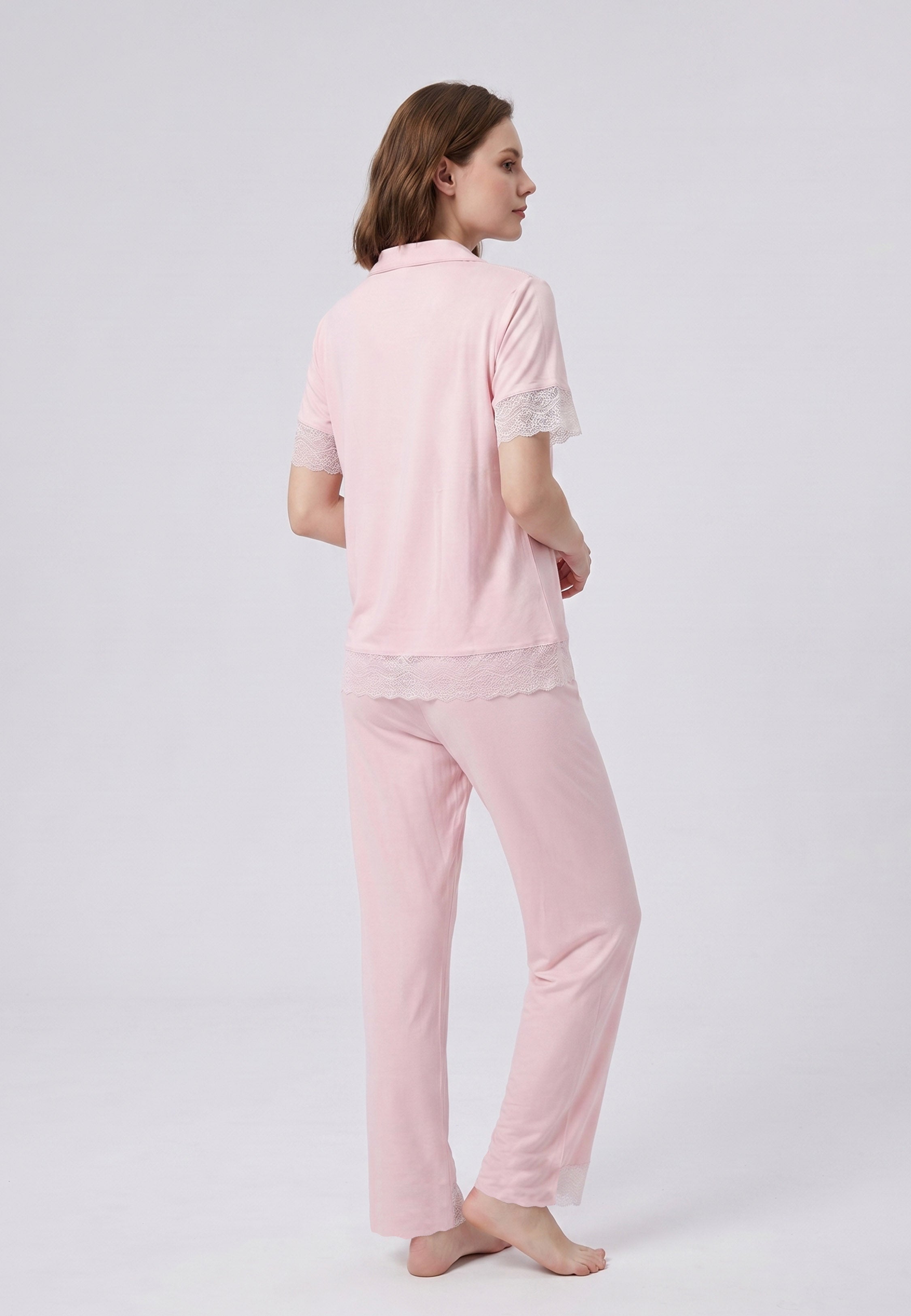 Femme portant un pyjama deux pièces chemise boutonnée unie dentelle rose clair et pantalon long uni dentelle aux chevilles Rosabella Chic Line