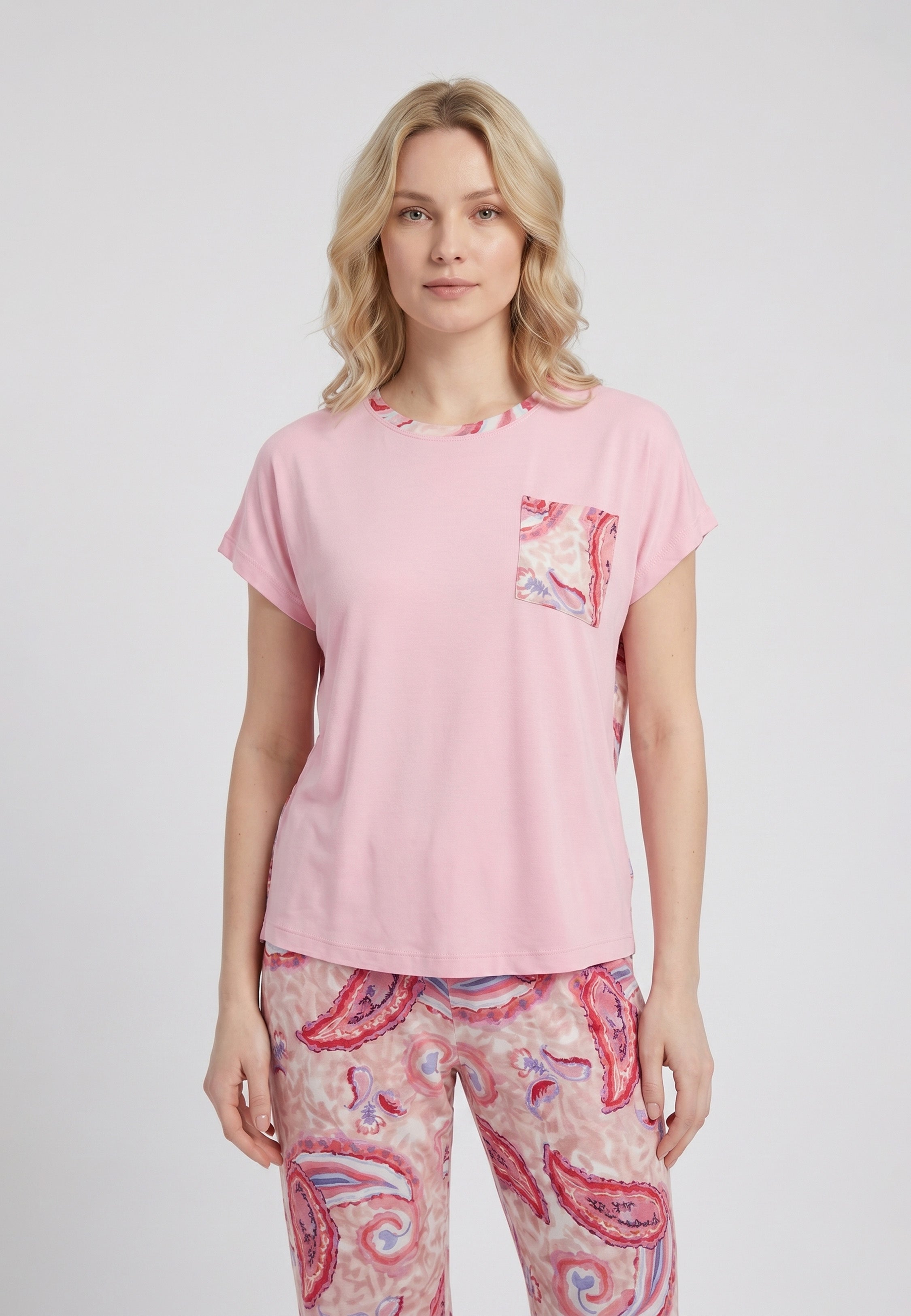Femme portant un pyjama deux pièces t-shirt oversize col rond uni rose poche poitrine imprimée paisley et pantalon droit imprimé paisley multicolore rose et rouge Rosabella Ethnique 2