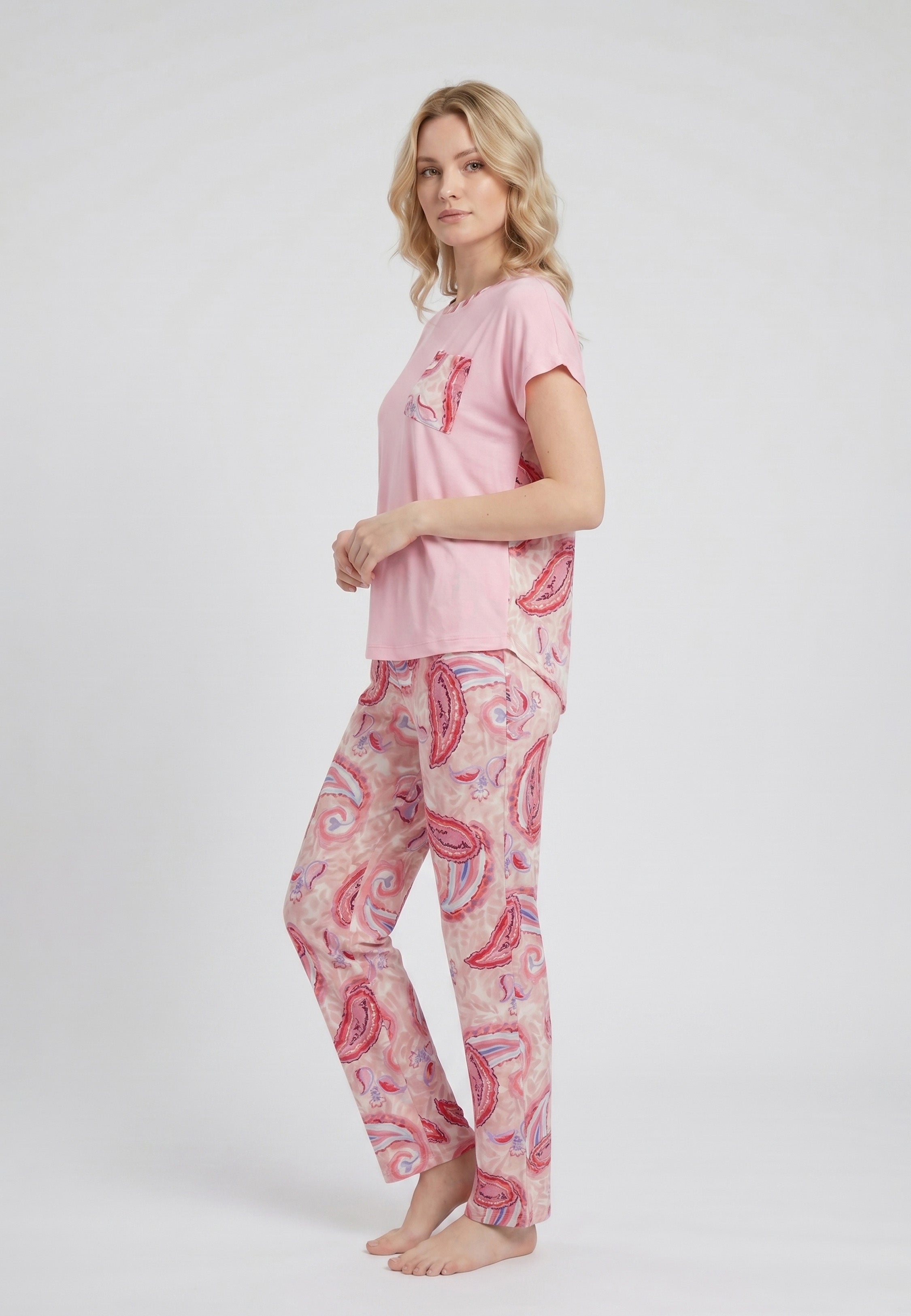 Femme portant un pyjama deux pièces t-shirt oversize col rond uni rose poche poitrine imprimée paisley et pantalon droit imprimé paisley multicolore rose et rouge Rosabella Ethnique 2