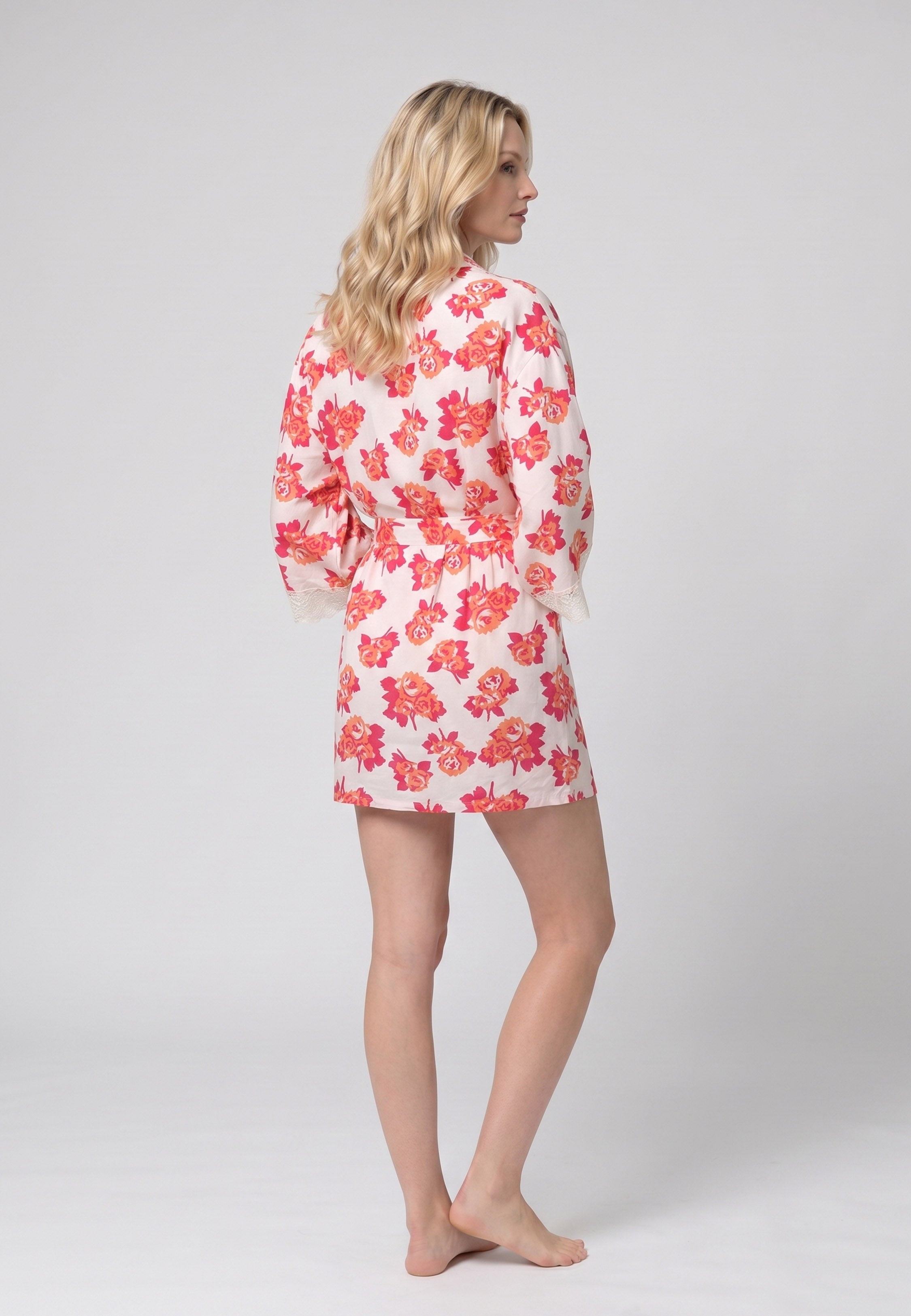 Femme portant un peignoir court croisé manches longues évasées dentelle imprimé fleuri orange et rose avec ceinture Rosabella Summer Time