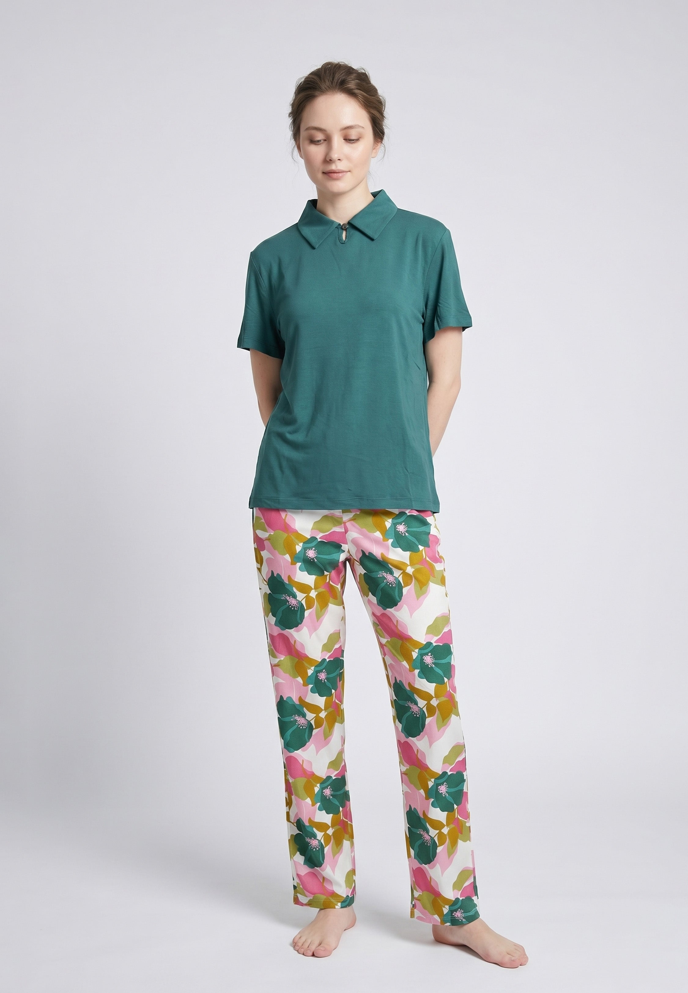 Femme portant un pyjama deux pièces top col polo zippé uni vert sapin et pantalon large grand imprimé fleuri multicolore vert rose et kaki Rosabella Mellow Moments