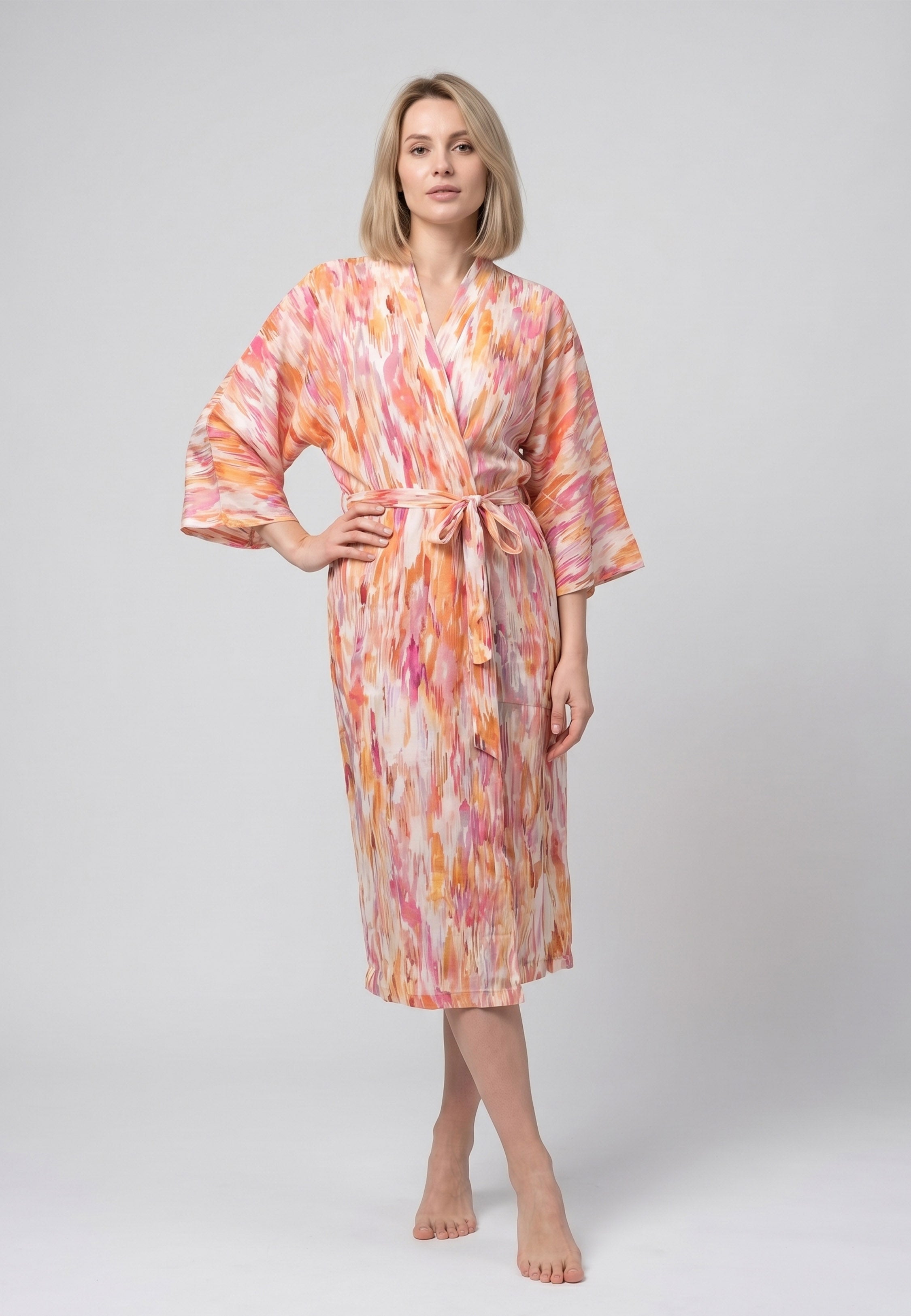 Femme portant un peignoir kimono midi croisé manches évasées imprimé aquarelle abstrait multicolore jaune et orangé avec ceinture Rosabella Soft Embrace