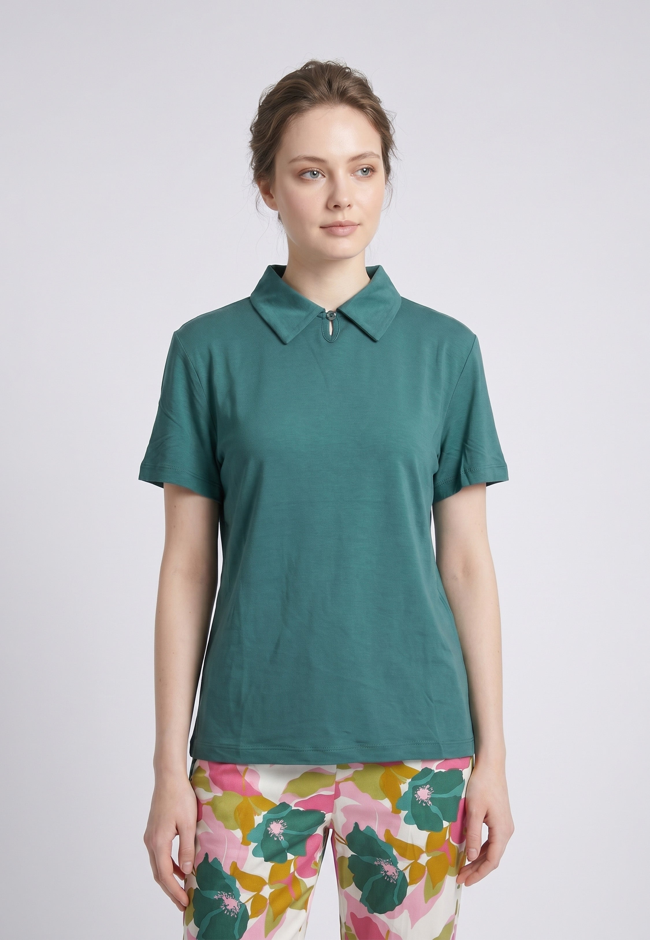 Femme portant un pyjama deux pièces top col polo zippé uni vert sapin et pantalon large grand imprimé fleuri multicolore vert rose et kaki Rosabella Mellow Moments