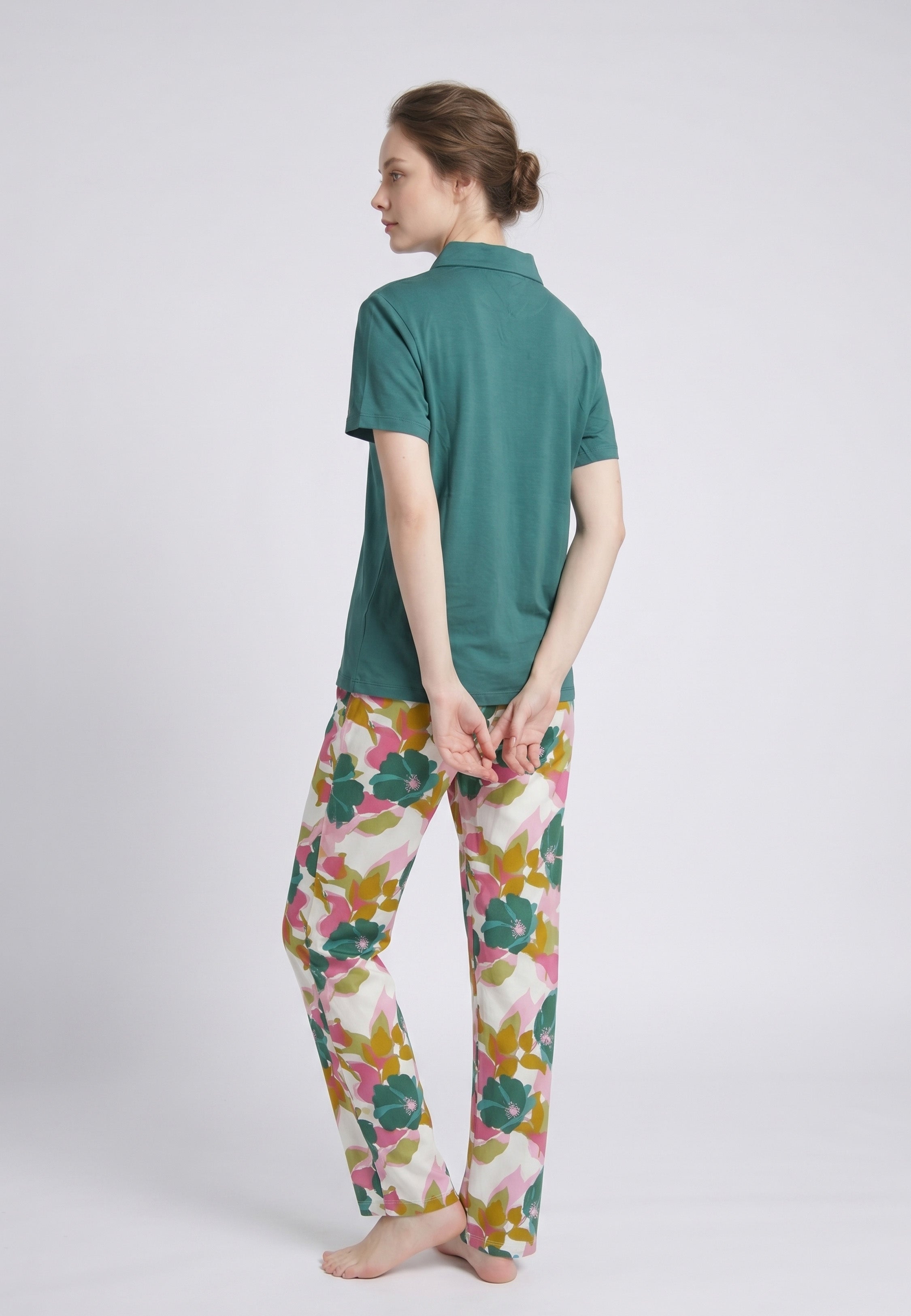 Femme portant un pyjama deux pièces top col polo zippé uni vert sapin et pantalon large grand imprimé fleuri multicolore vert rose et kaki Rosabella Mellow Moments