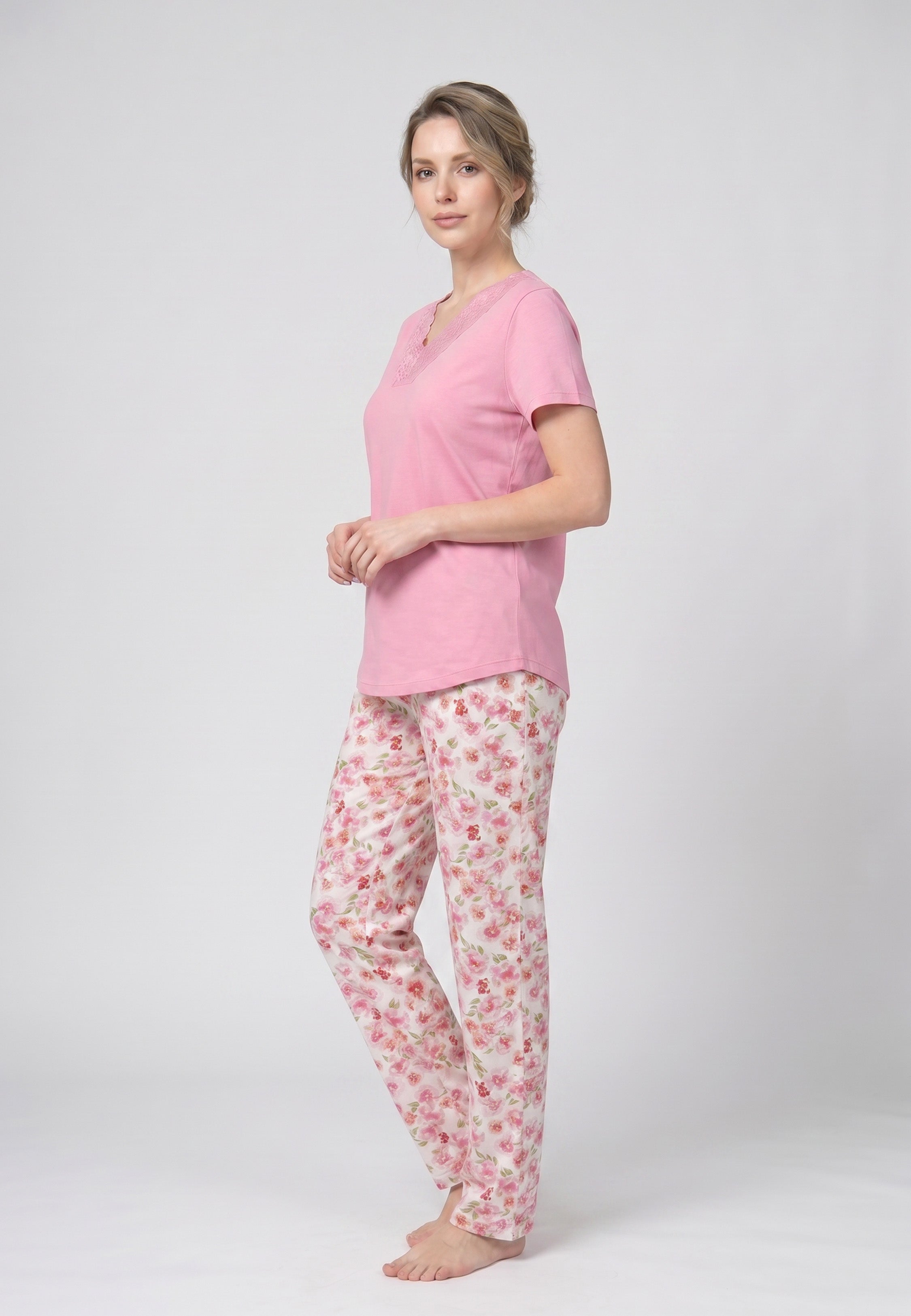 Femme portant un pyjama deux pièces t-shirt rose col V empiècement dentelle et pantalon long imprimé fleuri multicolore Rosabella Floralys