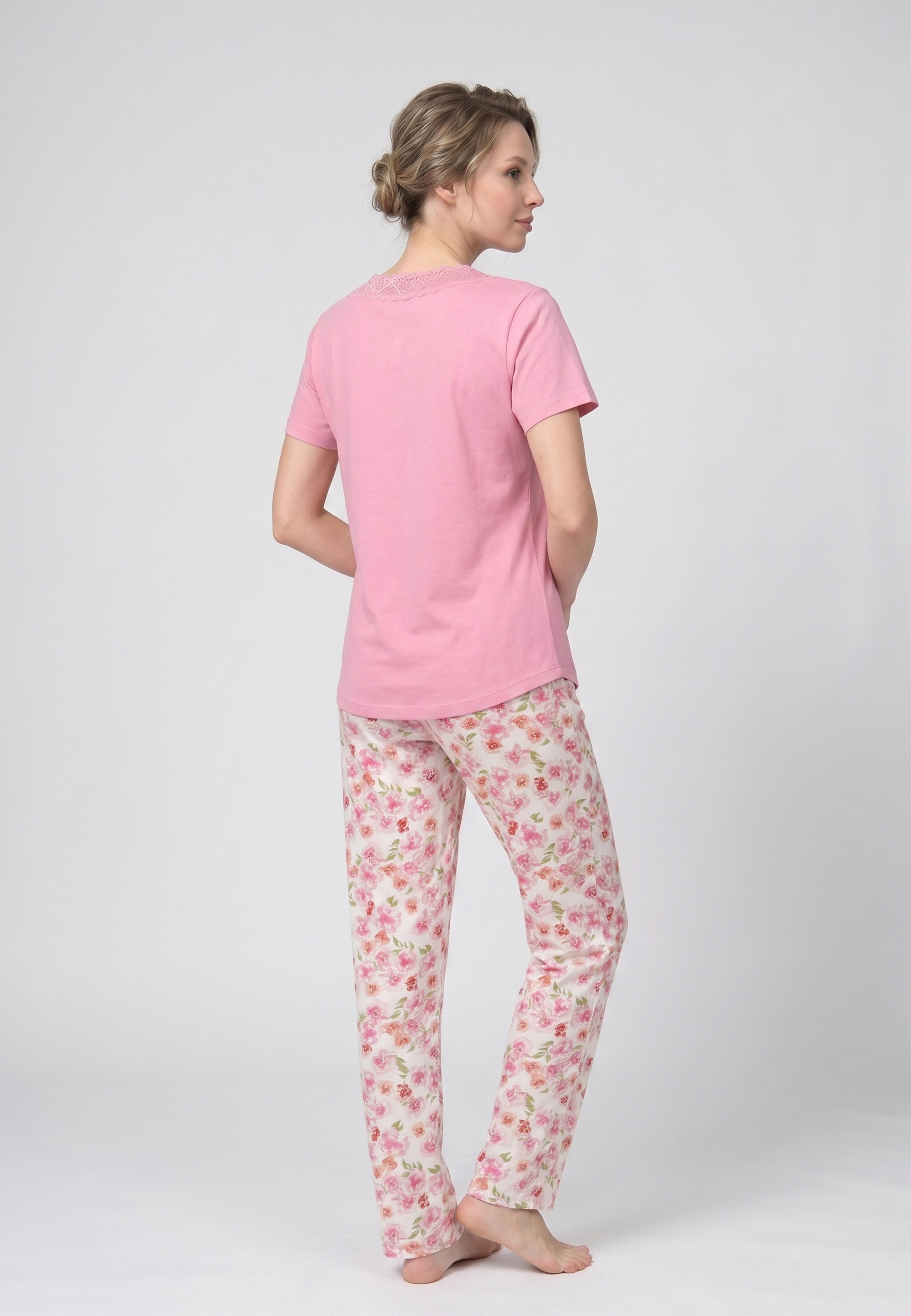 Femme portant un pyjama deux pièces t-shirt rose col V empiècement dentelle et pantalon long imprimé fleuri multicolore Rosabella Floralys