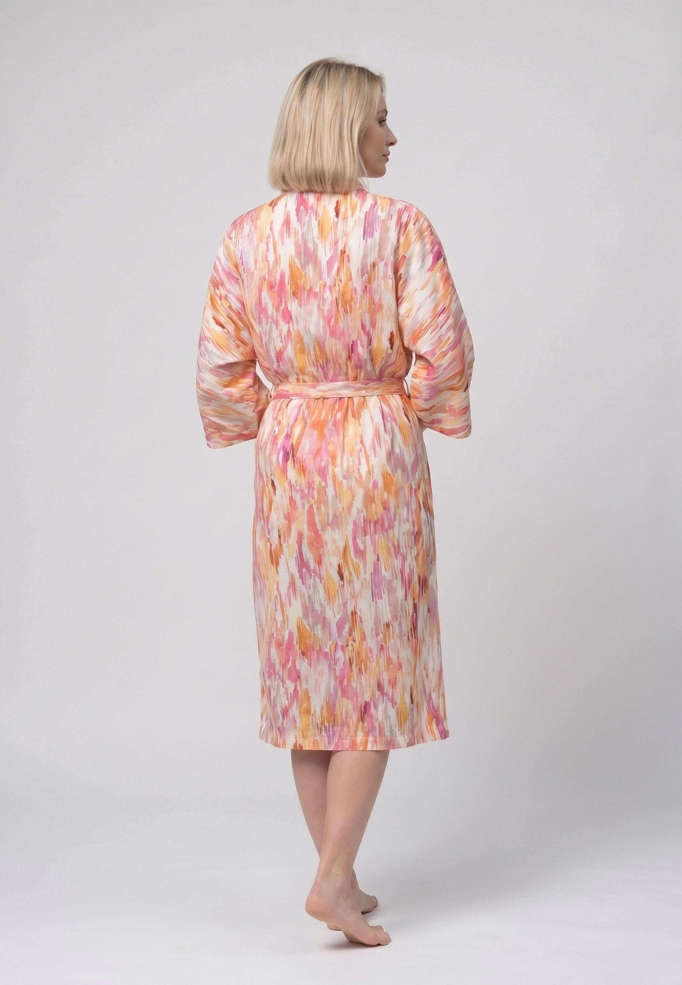 Femme portant un peignoir kimono midi croisé manches évasées imprimé aquarelle abstrait multicolore jaune et orangé avec ceinture Rosabella Soft Embrace