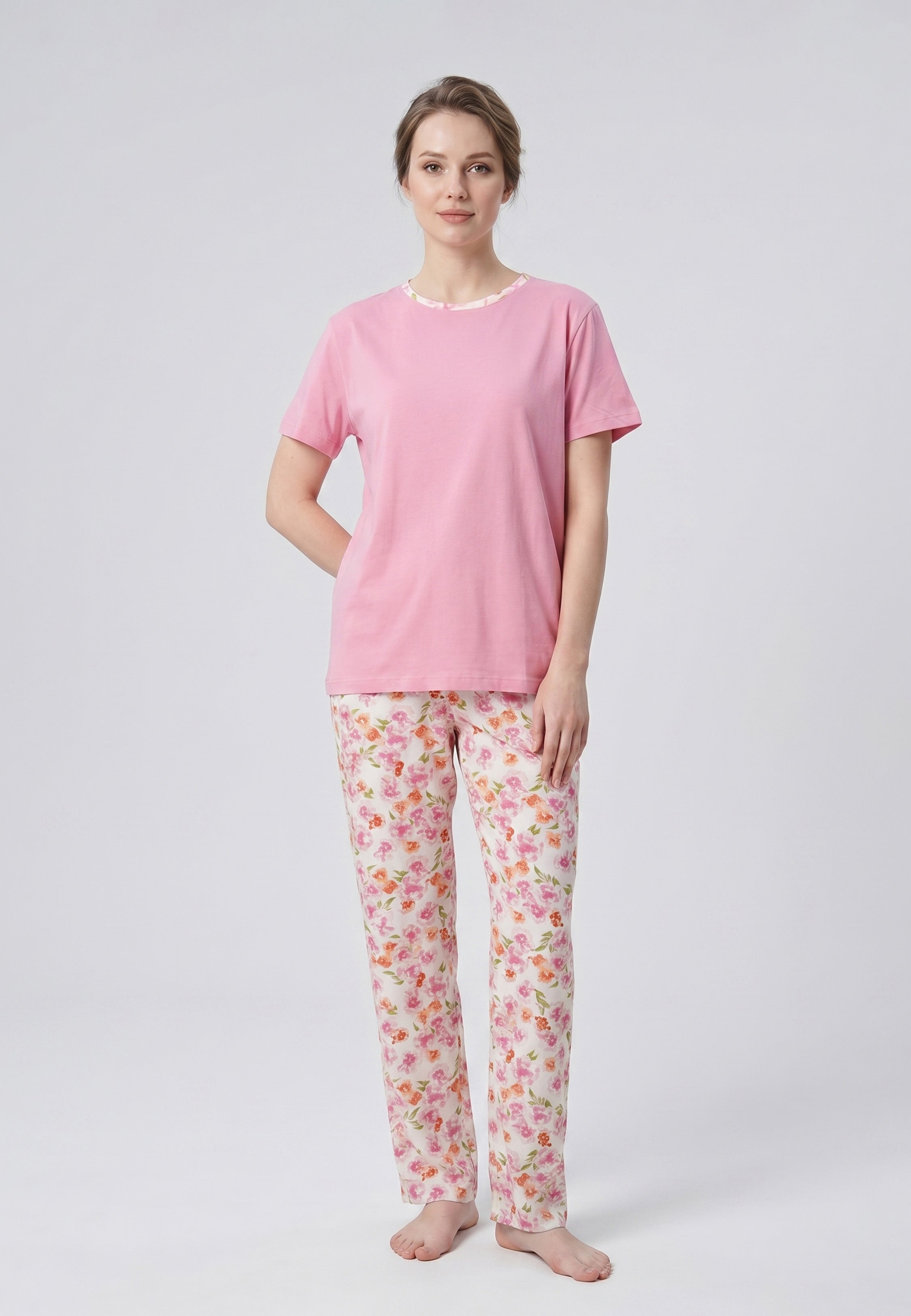 Femme portant un pyjama deux pièces t-shirt rose col rond liseré fleuri et pantalon long imprimé fleuri multicolore Rosabella Floralys