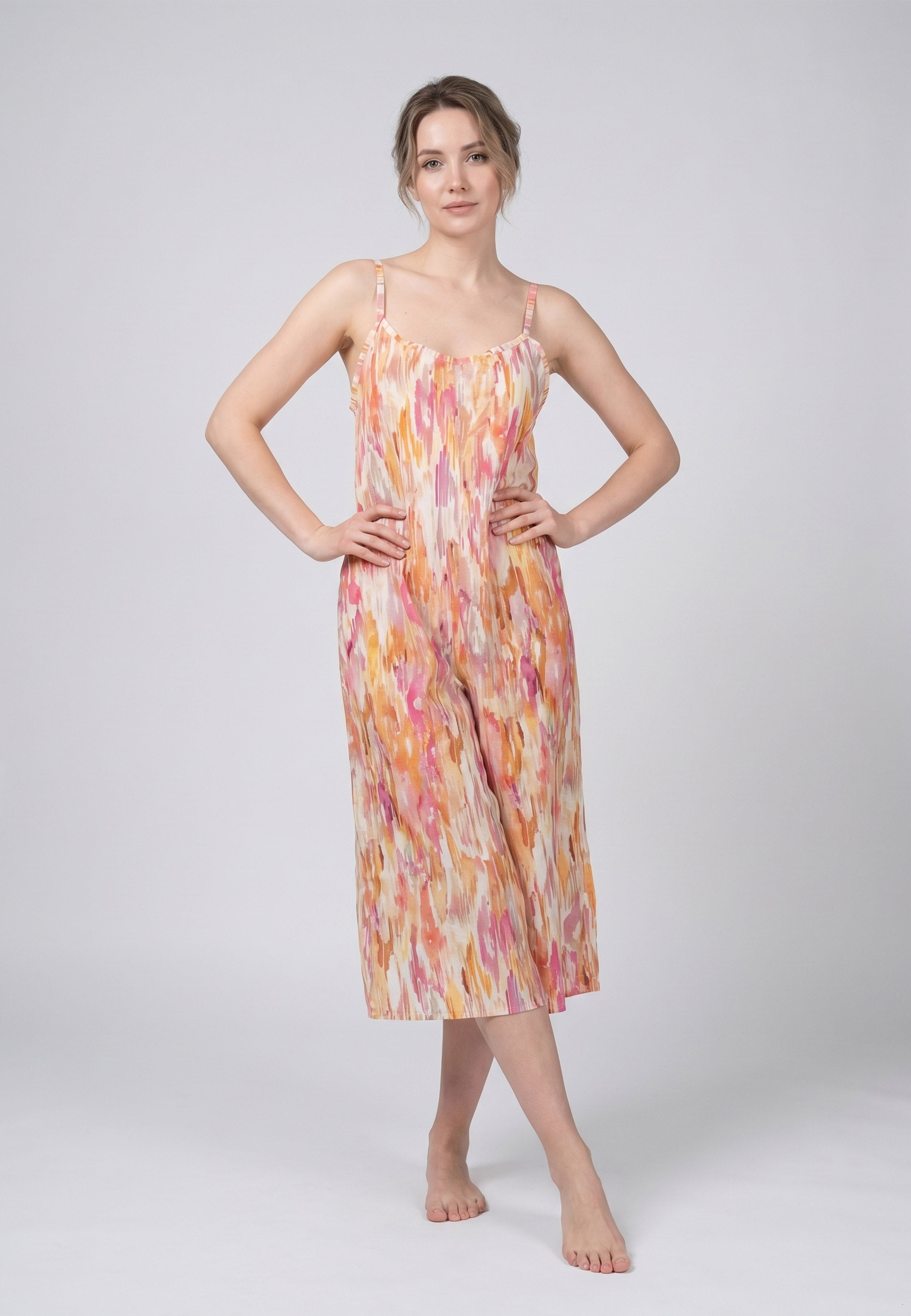 Femme portant une combinaison pyjama bretelles fines buste froncé jambes larges imprimé aquarelle abstrait multicolore jaune et orangé Rosabella Soft Embrace
