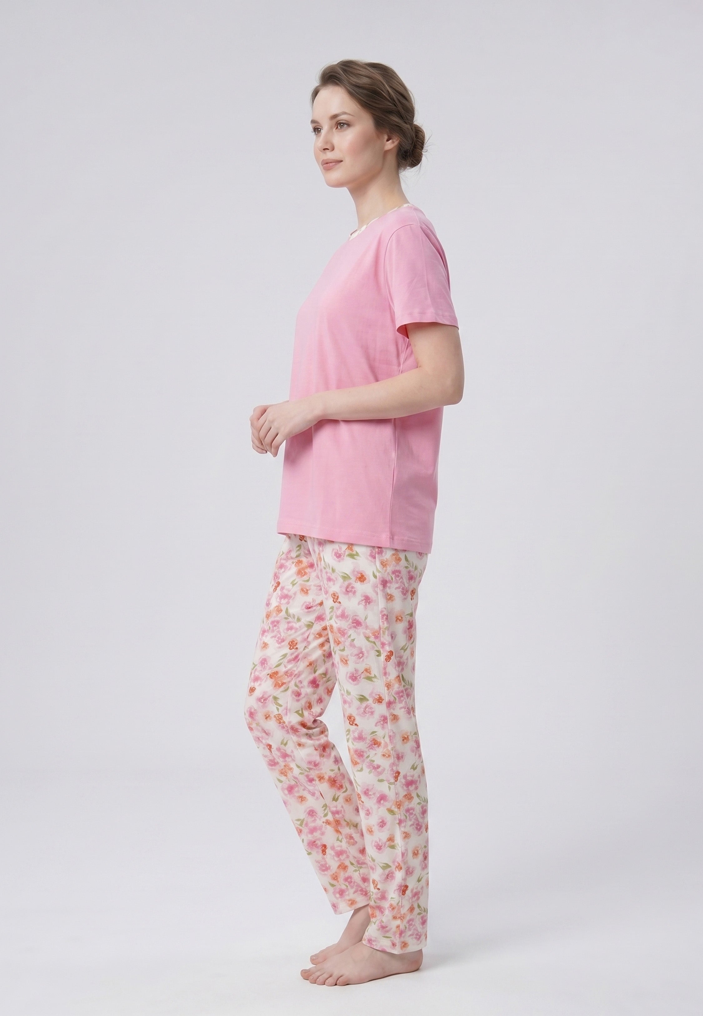 Femme portant un pyjama deux pièces t-shirt rose col rond liseré fleuri et pantalon long imprimé fleuri multicolore Rosabella Floralys