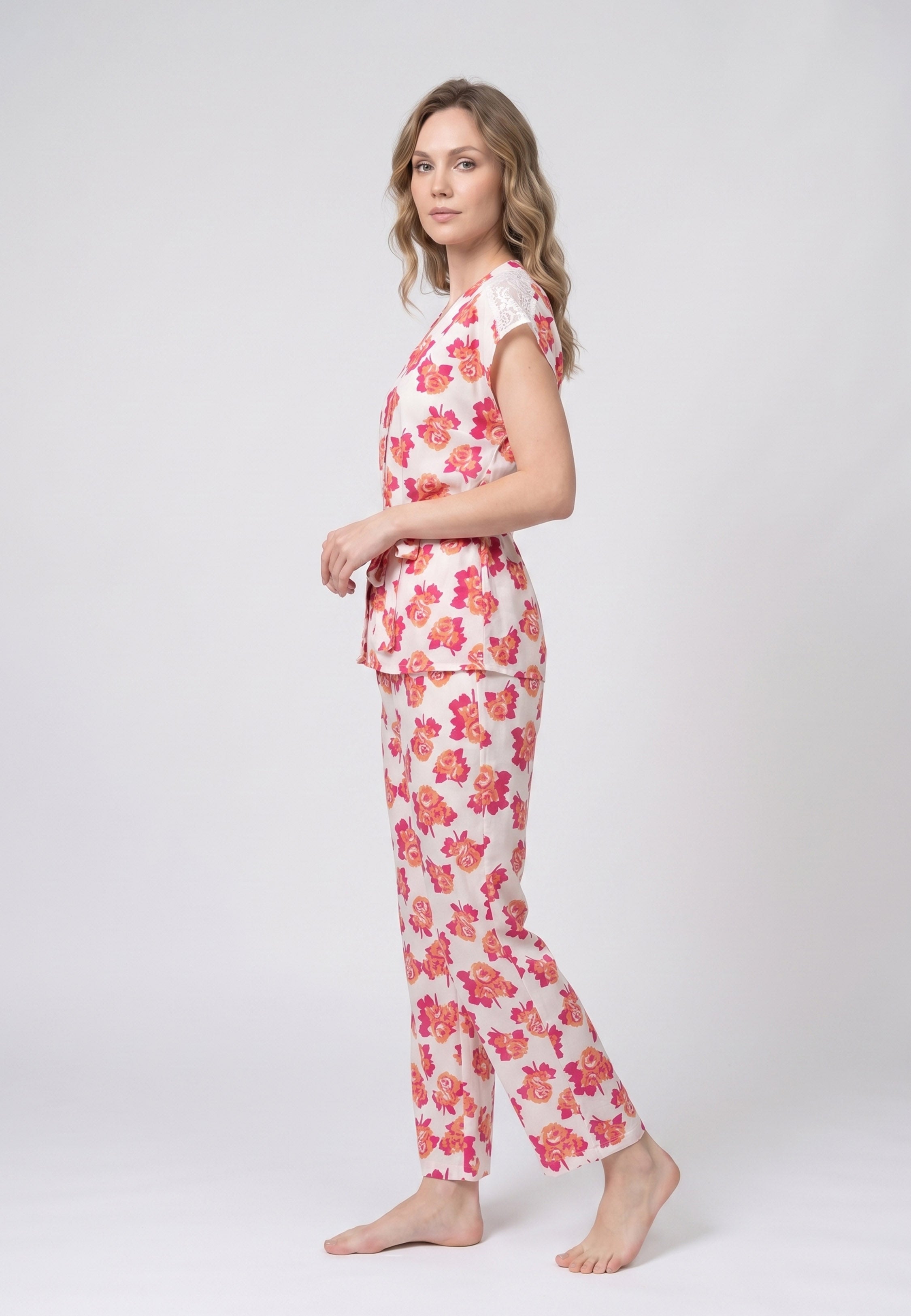 Femme portant un pyjama deux pièces blouse col V plissée imprimé fleuri multicolore orange et pantalon long assorti Rosabella Summer Time