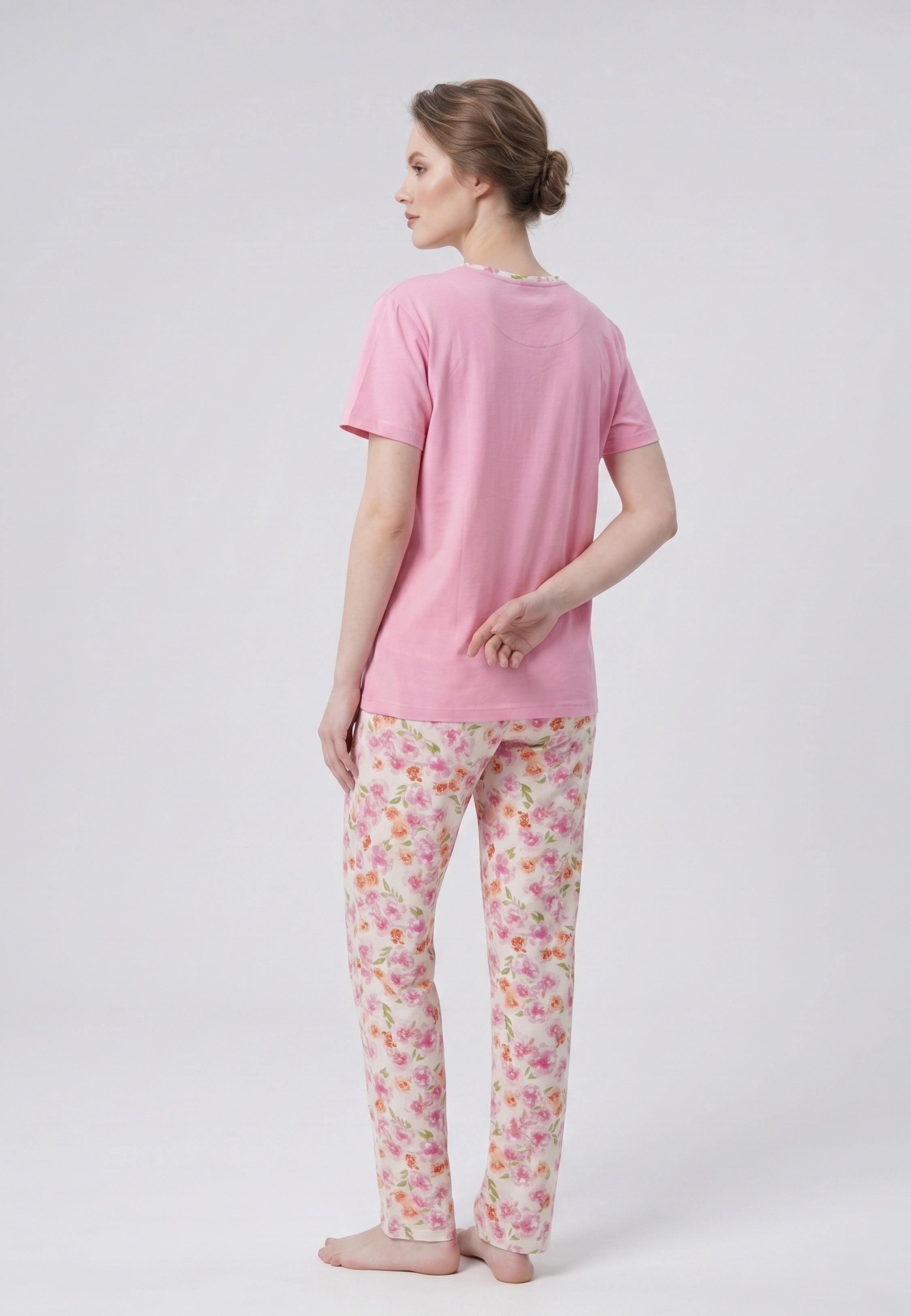 Femme portant un pyjama deux pièces t-shirt rose col rond liseré fleuri et pantalon long imprimé fleuri multicolore Rosabella Floralys
