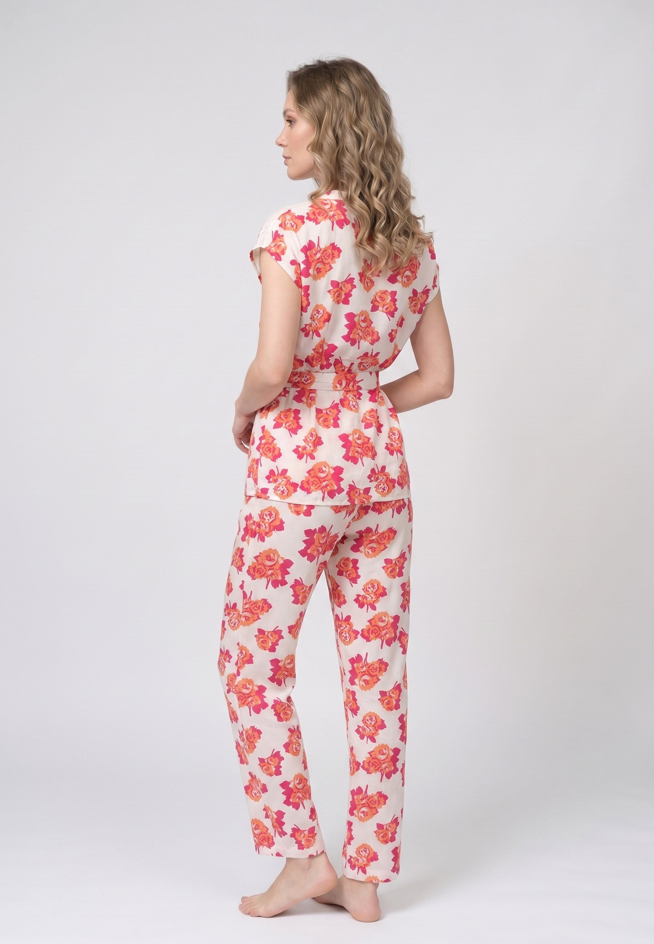 Femme portant un pyjama deux pièces blouse col V plissée imprimé fleuri multicolore orange et pantalon long assorti Rosabella Summer Time