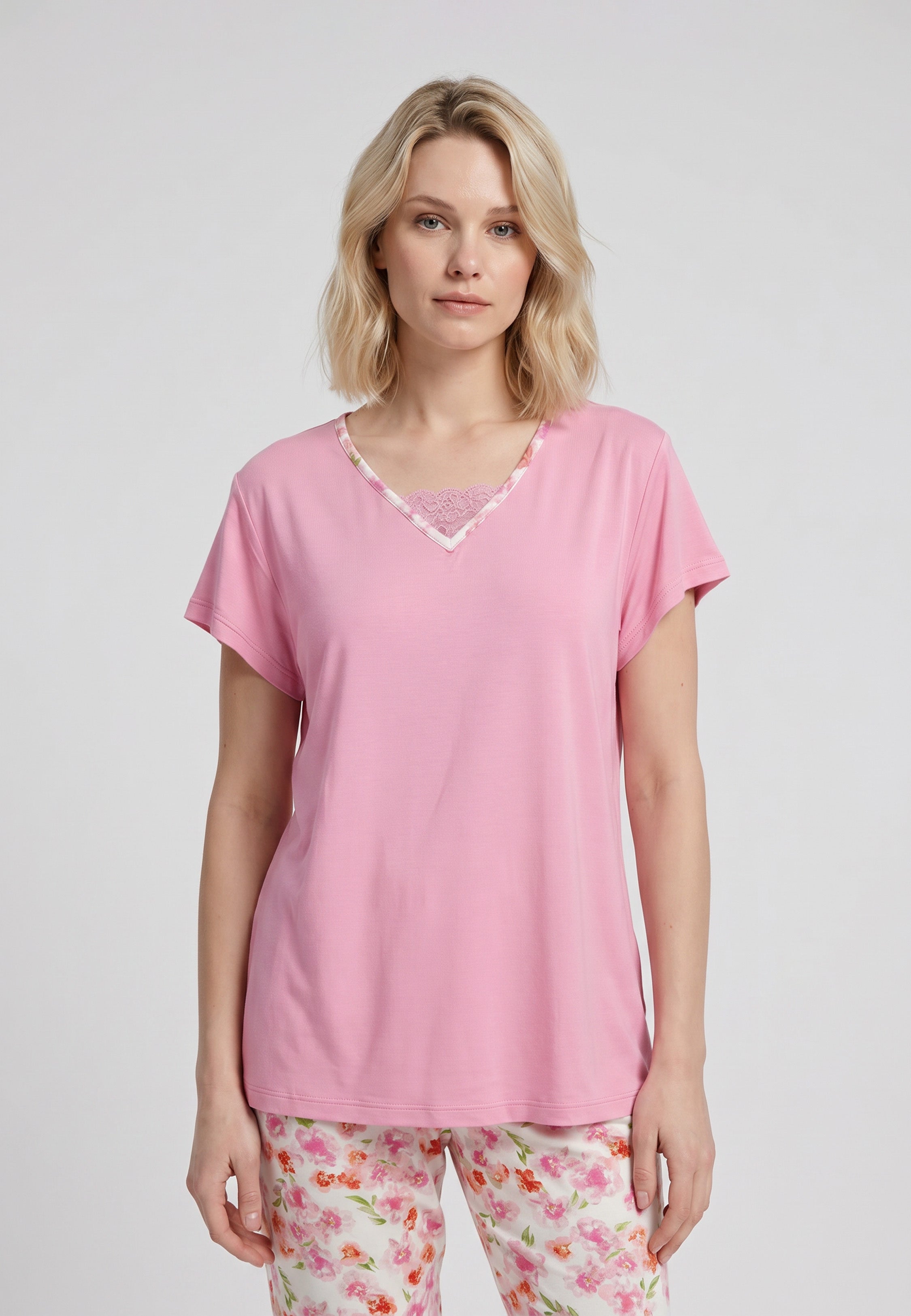 Femme portant un pyjama deux pièces t-shirt rose col V liseré dentelle et pantalon long imprimé fleuri multicolore Rosabella Floralys