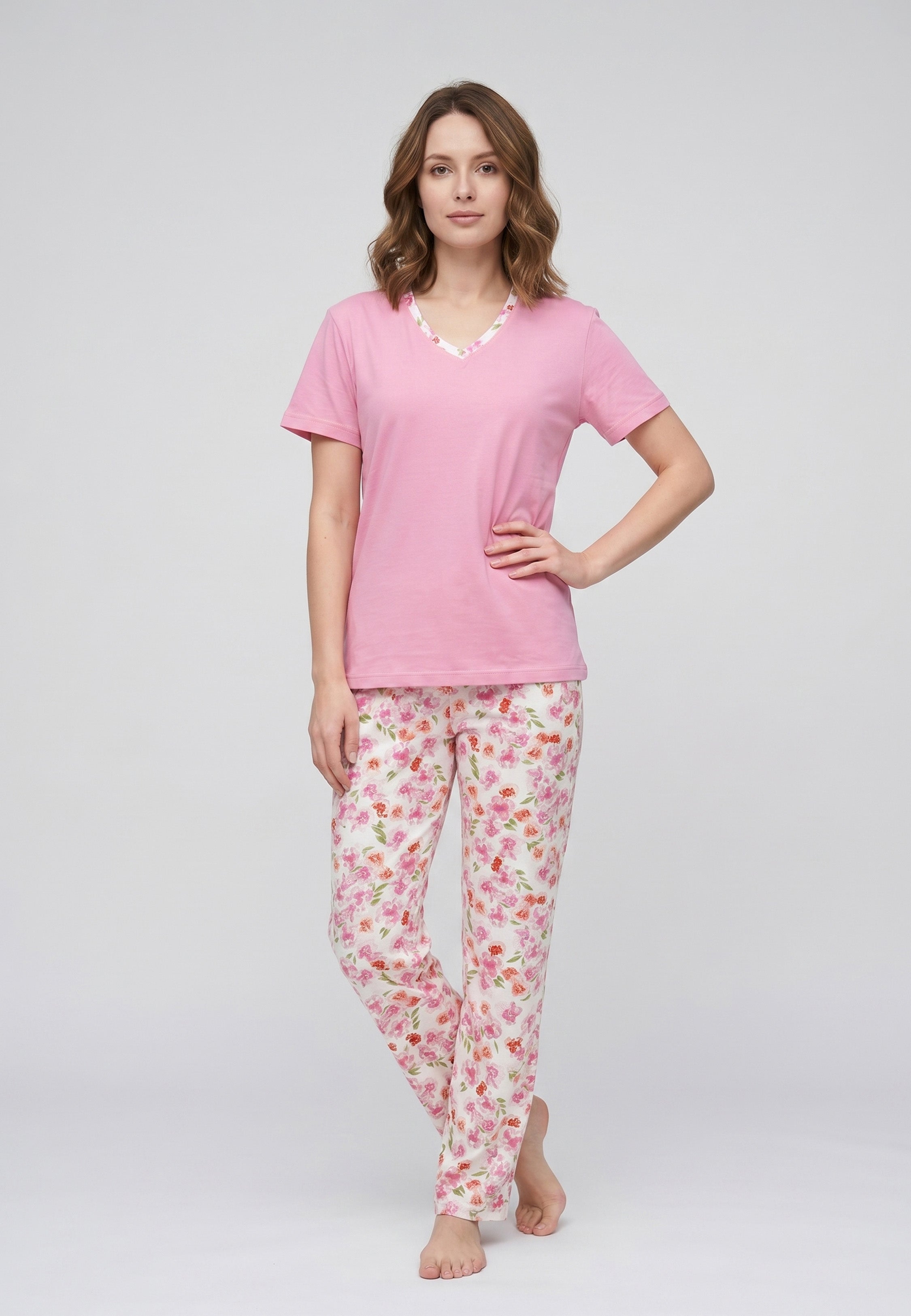 Femme portant un pyjama deux pièces t-shirt rose col V liseré fleuri et pantalon long imprimé fleuri multicolore Rosabella Floralys