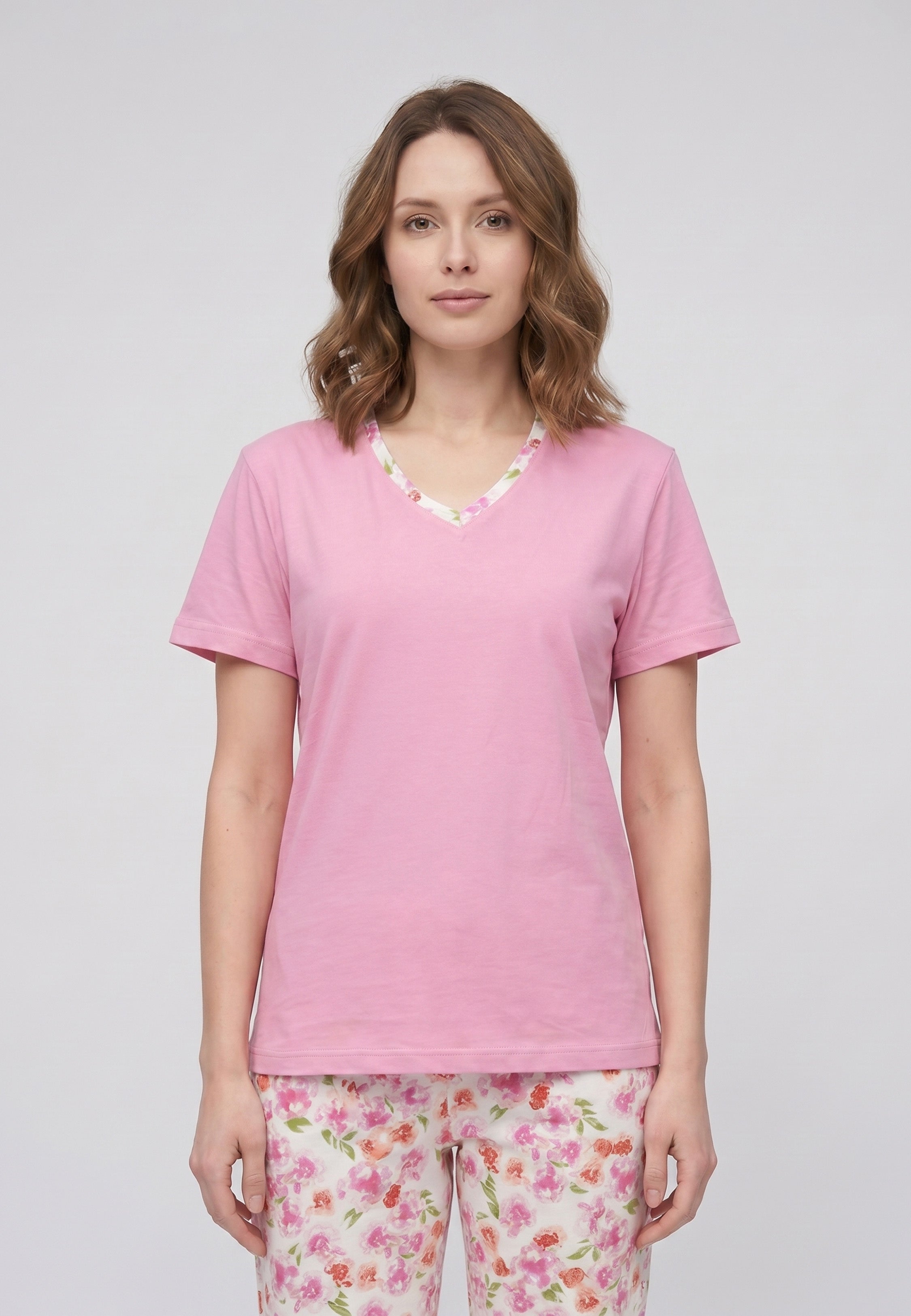 Femme portant un pyjama deux pièces t-shirt rose col V liseré fleuri et pantalon long imprimé fleuri multicolore Rosabella Floralys