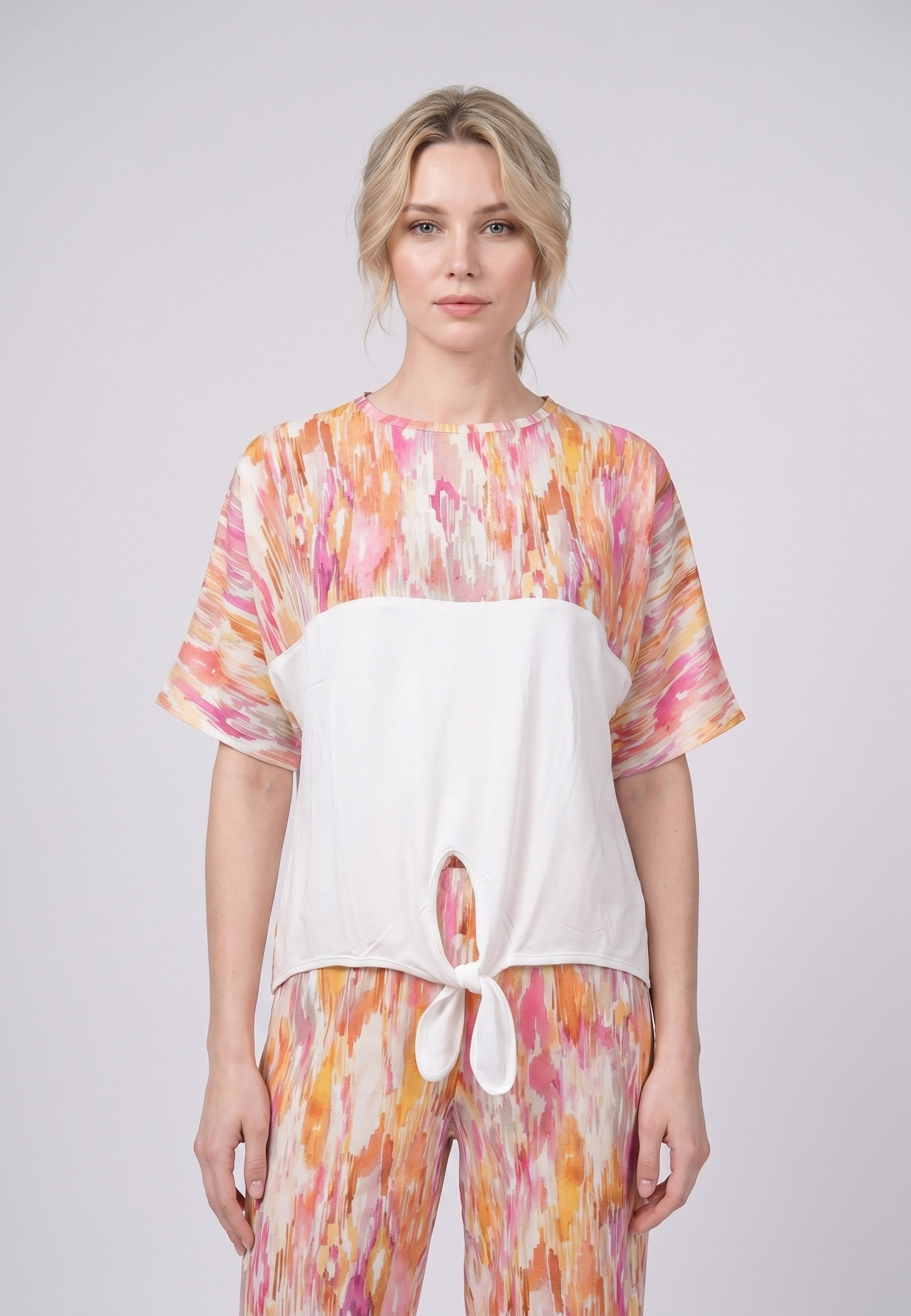 Femme portant un pyjama deux pièces top col rond bicolore nœud frontal imprimé aquarelle et pantalon large imprimé aquarelle abstrait jaune Rosabella Soft Embrace