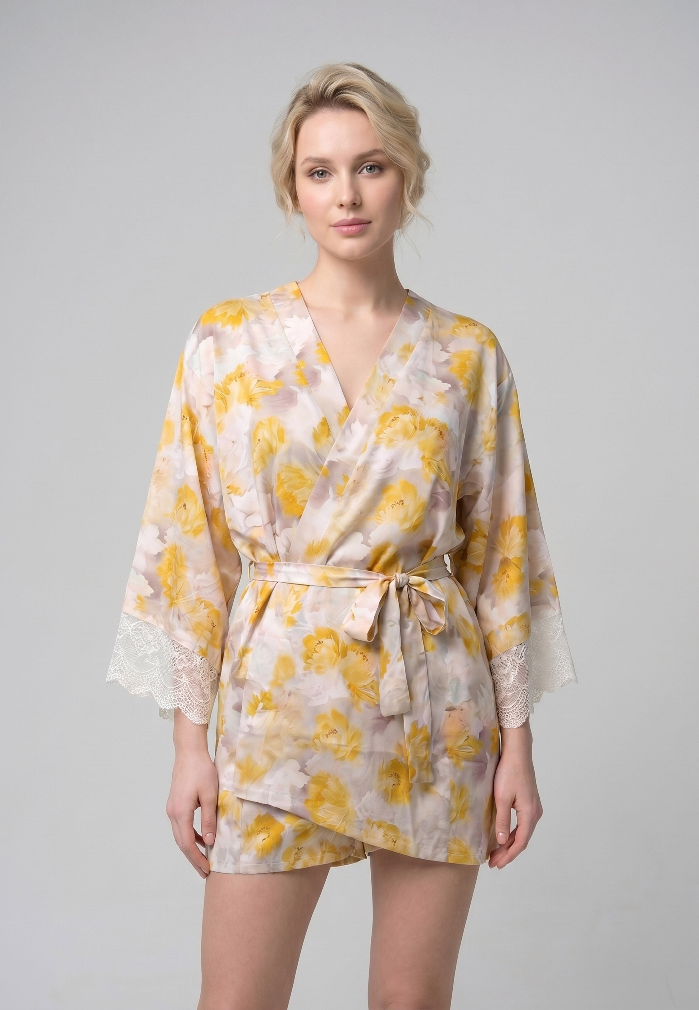 Femme portant un peignoir court croisé manches longues évasées dentelle imprimé fleuri jaune et rose avec ceinture Rosabella Summer Time
