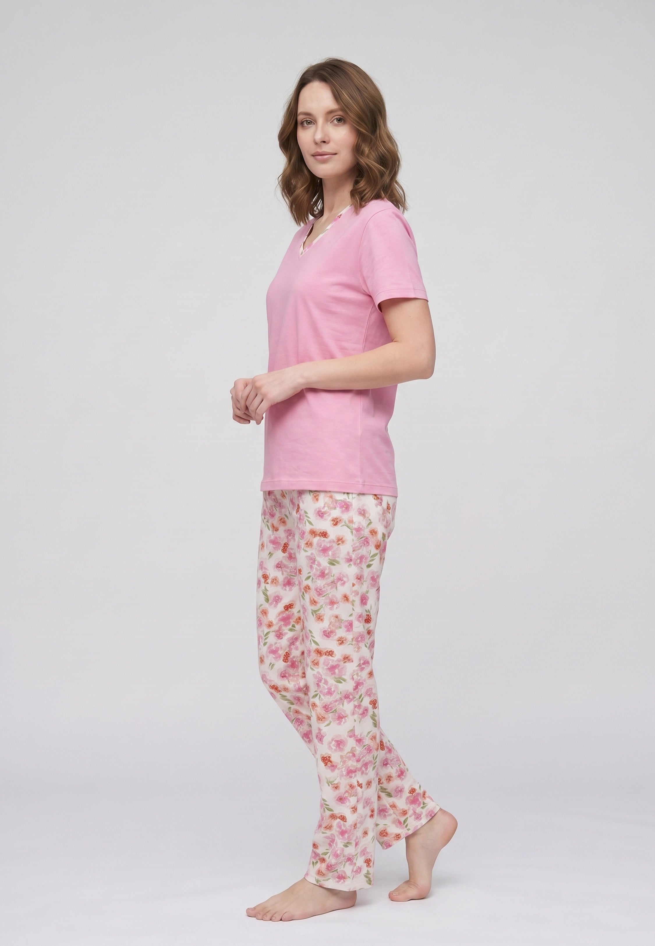 Femme portant un pyjama deux pièces t-shirt rose col V liseré fleuri et pantalon long imprimé fleuri multicolore Rosabella Floralys