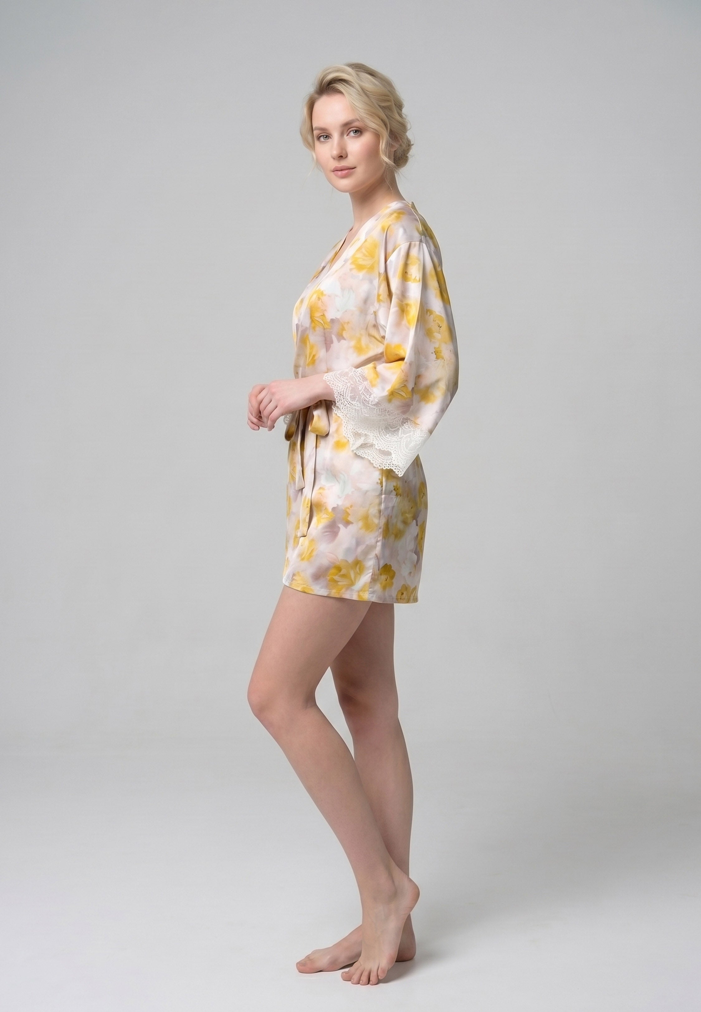 Femme portant un peignoir court croisé manches longues évasées dentelle imprimé fleuri jaune et rose avec ceinture Rosabella Summer Time