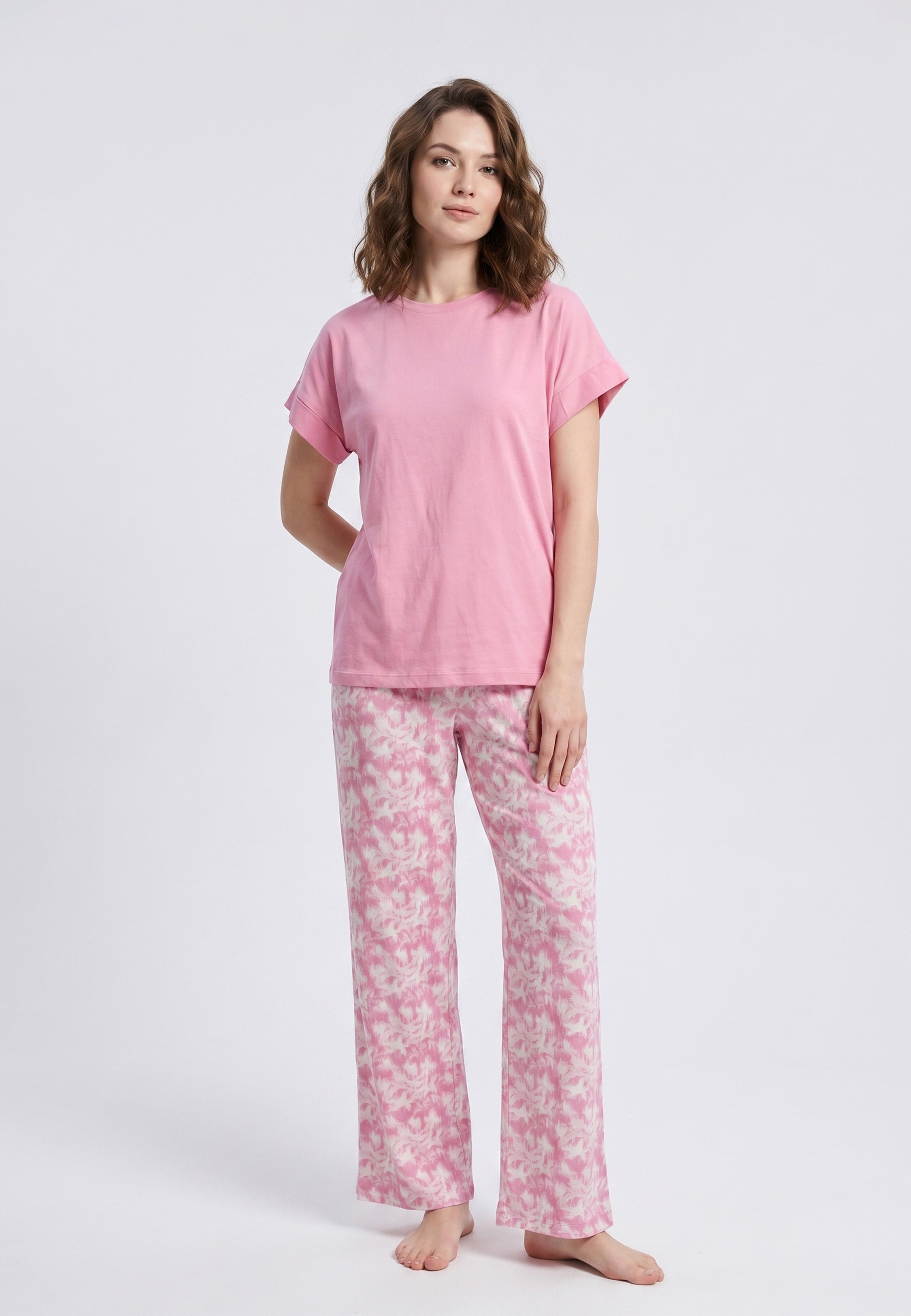 Femme portant un pyjama deux pièces t-shirt rose foncé uni et pantalon large imprimé aquarelle rose et blanc Rosabella Fleurs Sauvages