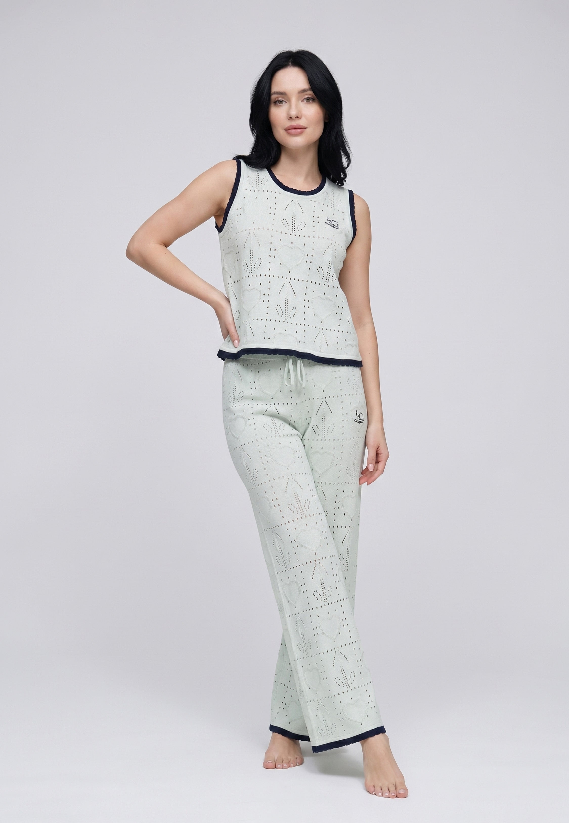 Femme portant un ensemble débardeur maille pointelle botaniques crème liséré rouge et pantalon large assorti Rosabella