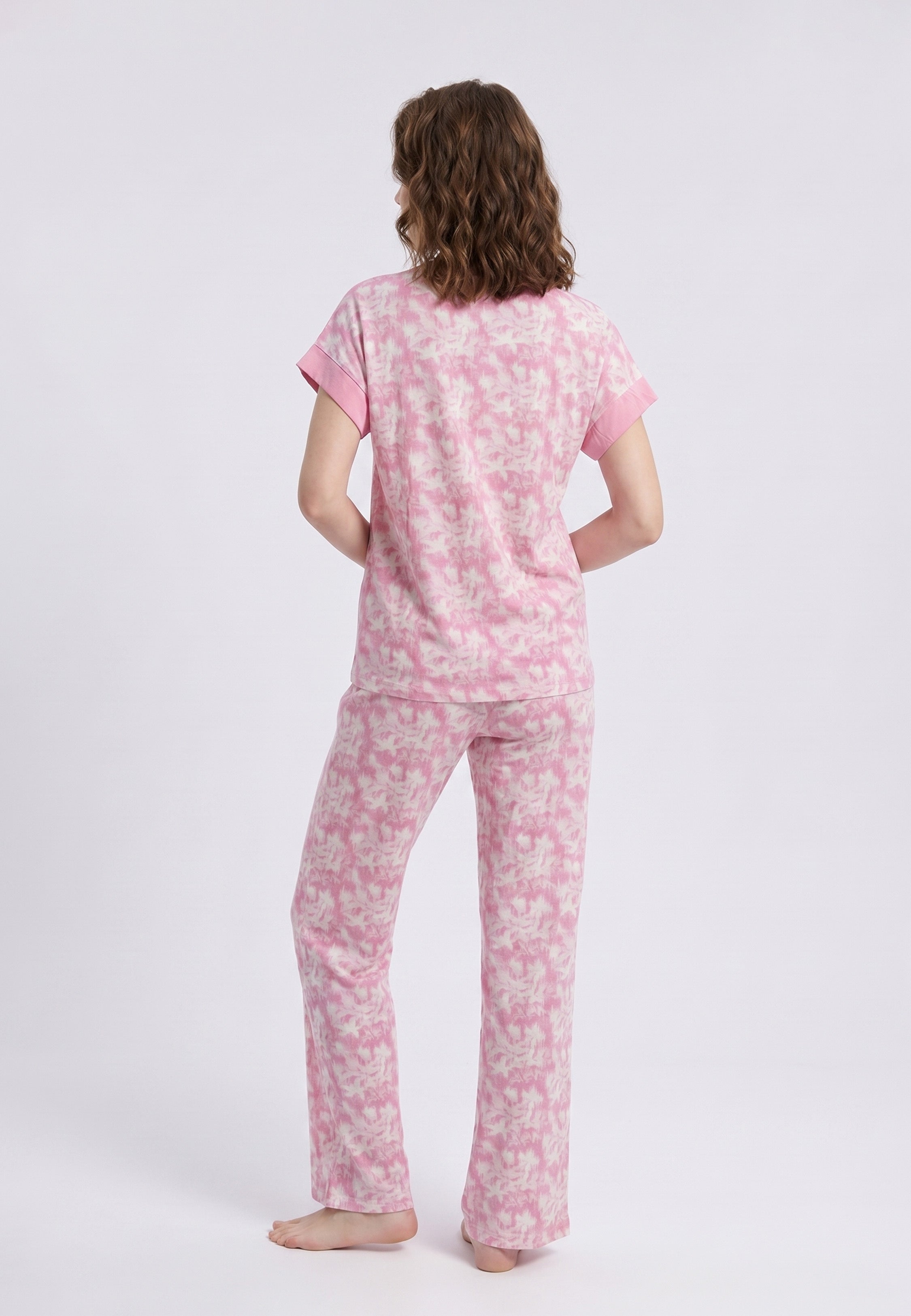 Femme portant un pyjama deux pièces t-shirt rose foncé uni et pantalon large imprimé aquarelle rose et blanc Rosabella Fleurs Sauvages