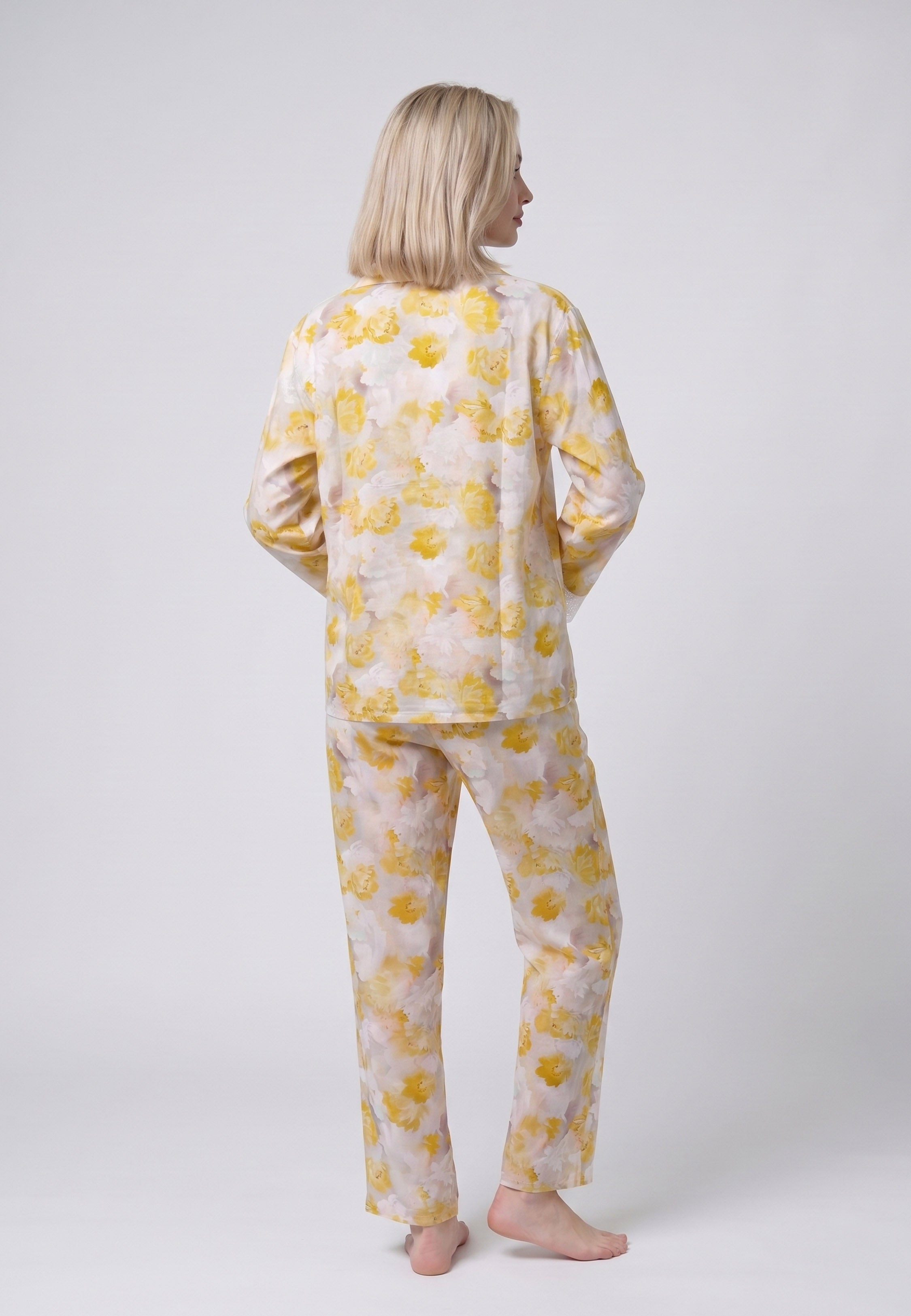 Femme portant un pyjama deux pièces chemise boutonnée manches longues dentelle imprimé fleuri aquarelle jaune et pantalon long assorti Rosabella Summer