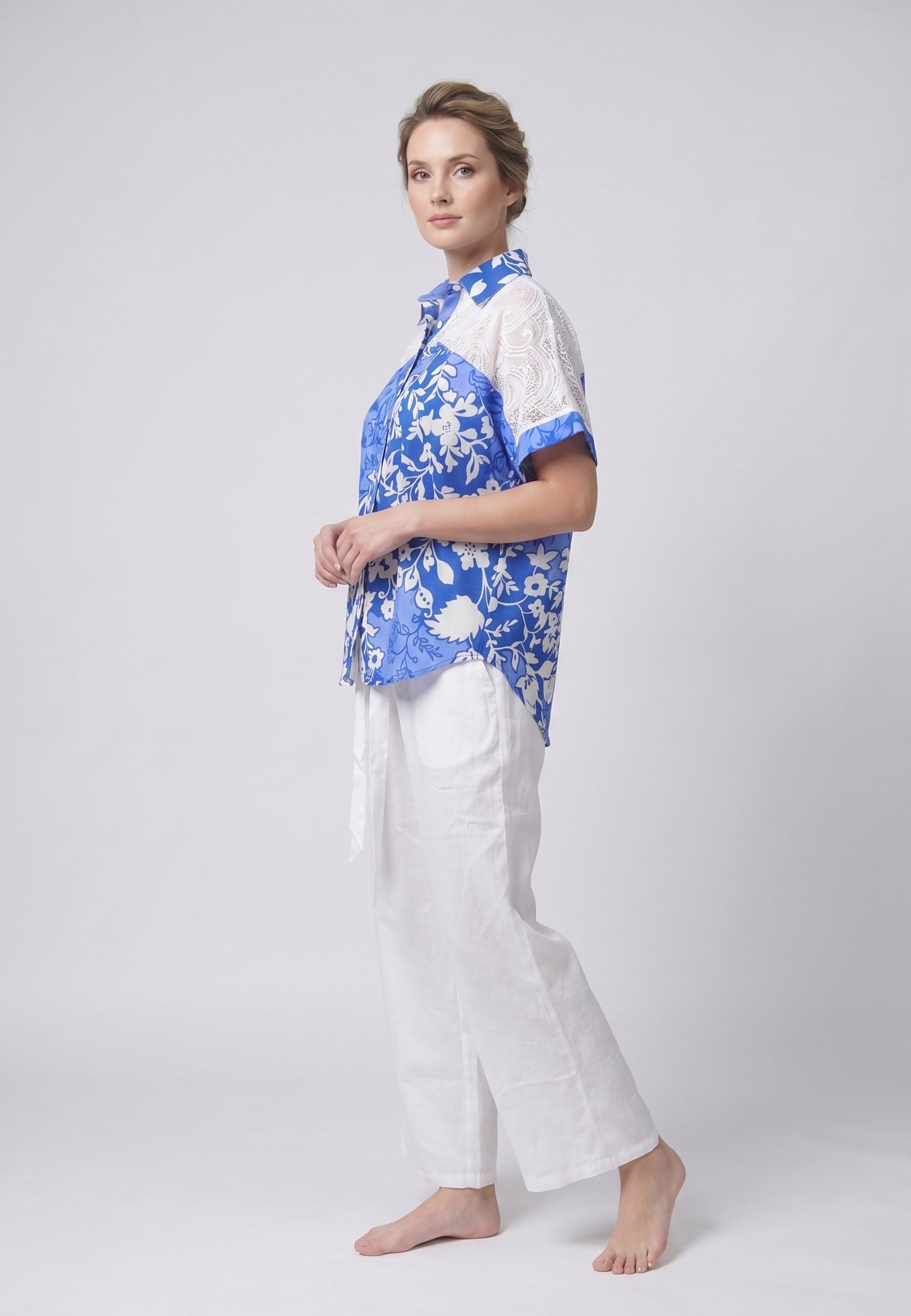 Femme portant un pyjama deux pièces chemise boutonnée dentelle crochet imprimé fleuri bleu et blanc et pantalon large uni blanc Rosabella Jasmine Nights