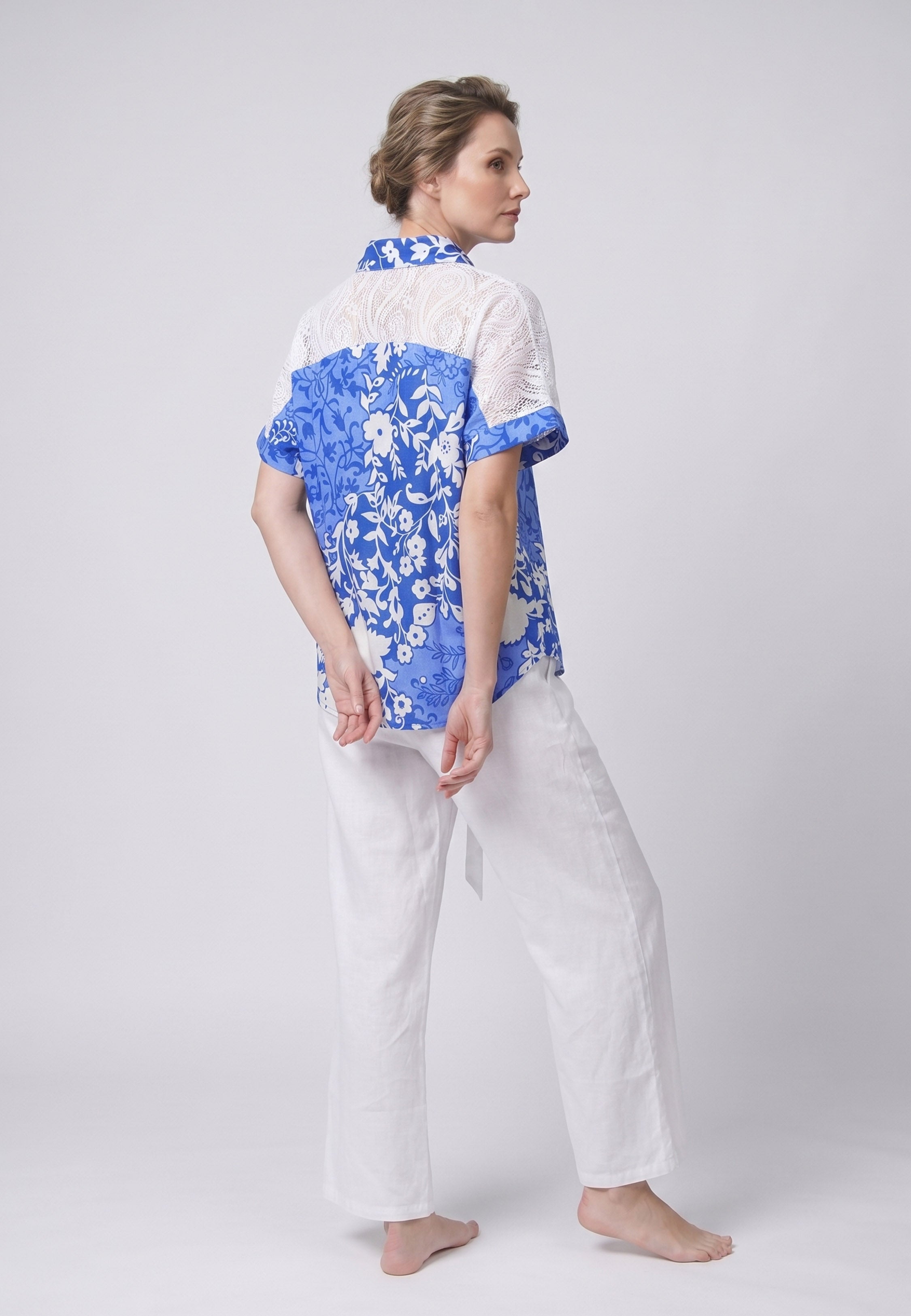 Femme portant un pyjama deux pièces chemise boutonnée dentelle crochet imprimé fleuri bleu et blanc et pantalon large uni blanc Rosabella Jasmine Nights