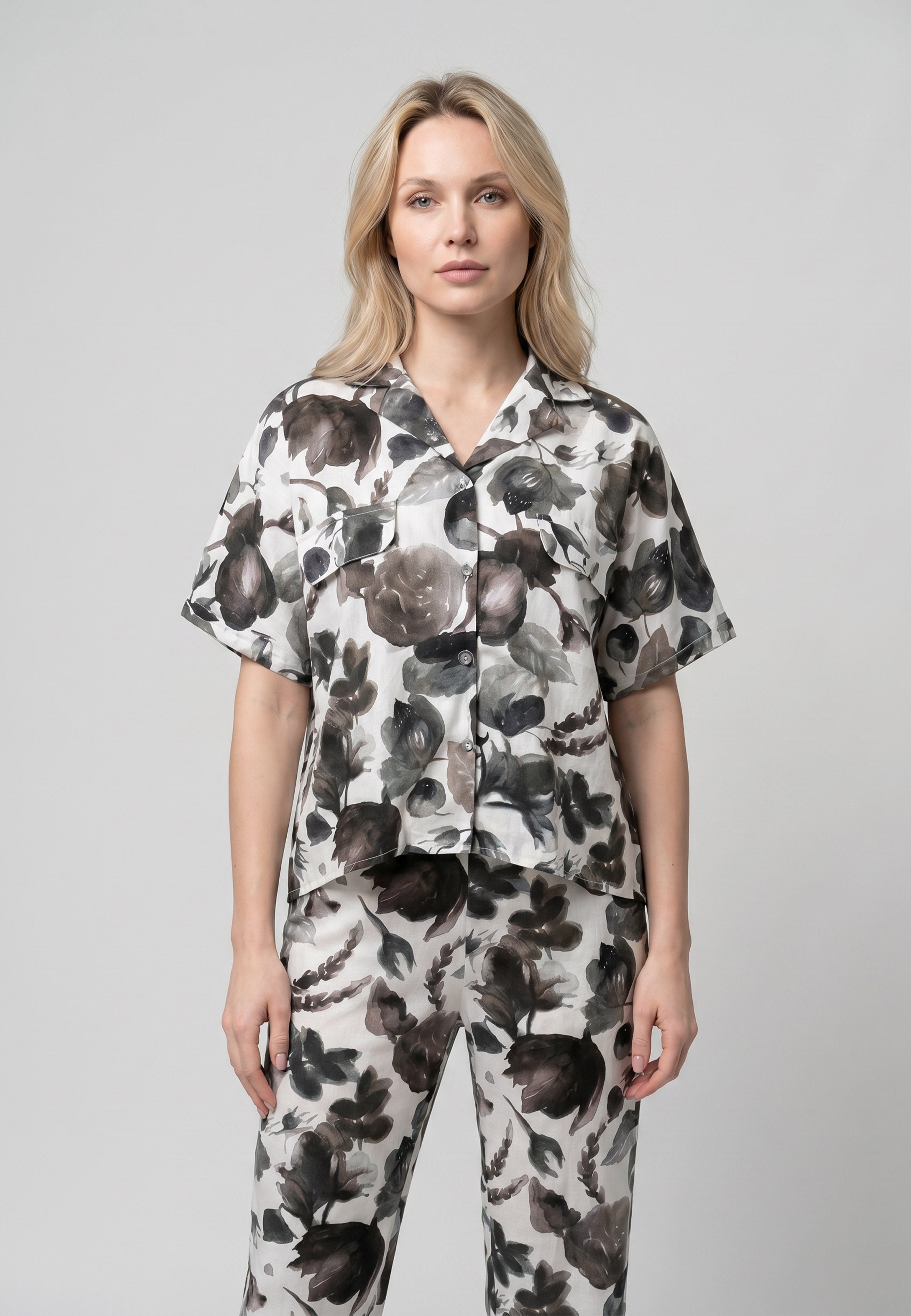 Femme portant un pyjama deux pièces chemise boutonnée col revers imprimé fleuri aquarelle noir et gris et pantalon long assorti Rosabella Cozy Comforts