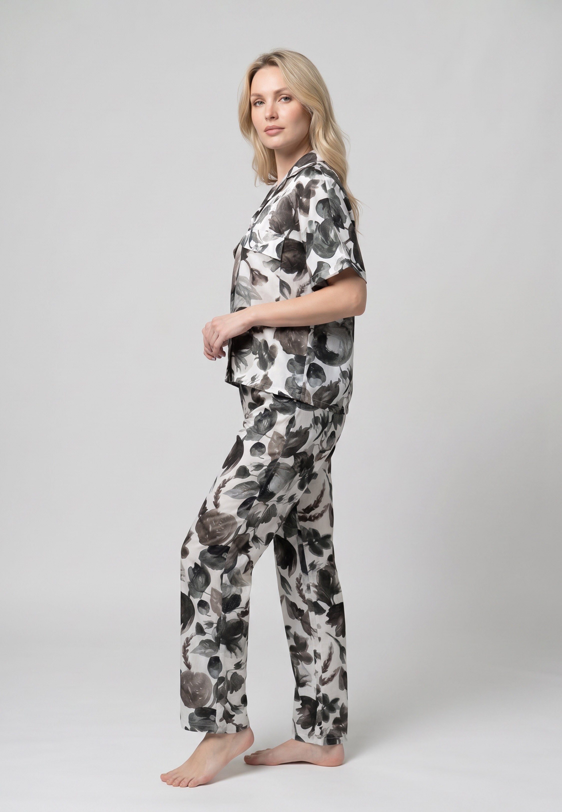 Femme portant un pyjama deux pièces chemise boutonnée col revers imprimé fleuri aquarelle noir et gris et pantalon long assorti Rosabella Cozy Comforts