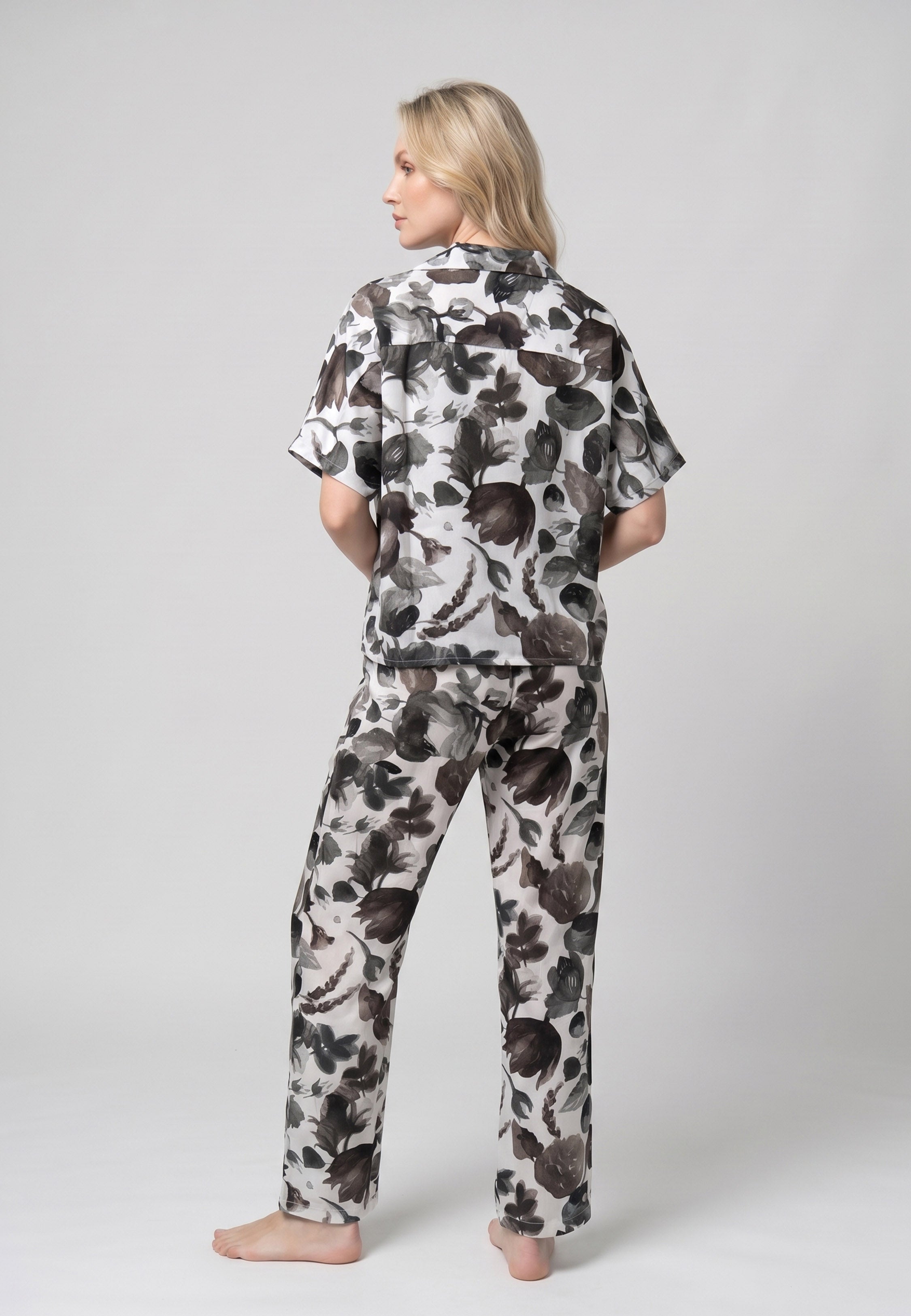Femme portant un pyjama deux pièces chemise boutonnée col revers imprimé fleuri aquarelle noir et gris et pantalon long assorti Rosabella Cozy Comforts