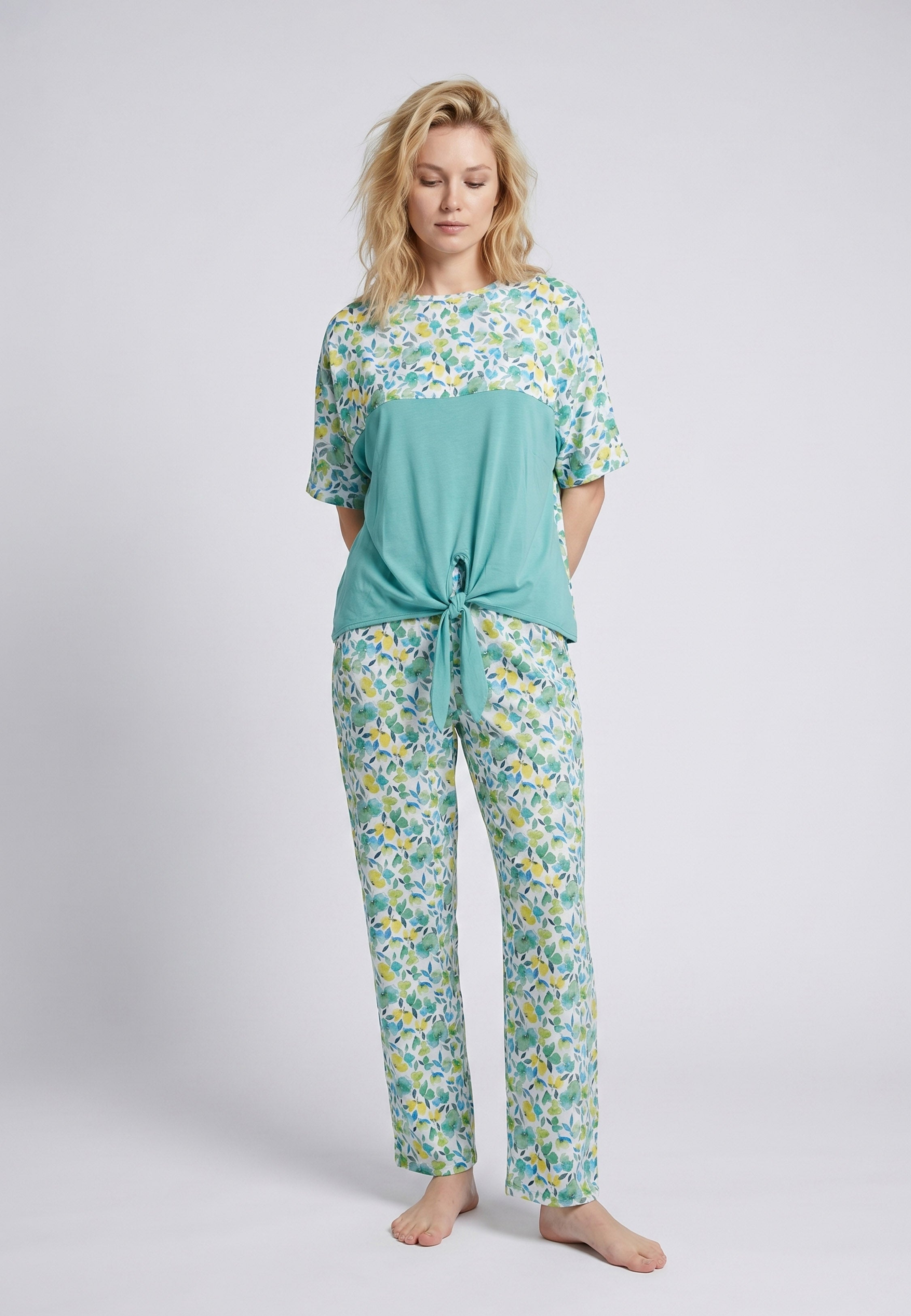 Femme portant un pyjama deux pièces top col rond bicolore nœud frontal empiècement fleuri et pantalon long imprimé fleuri vert et jaune Rosabella Soft Embrace