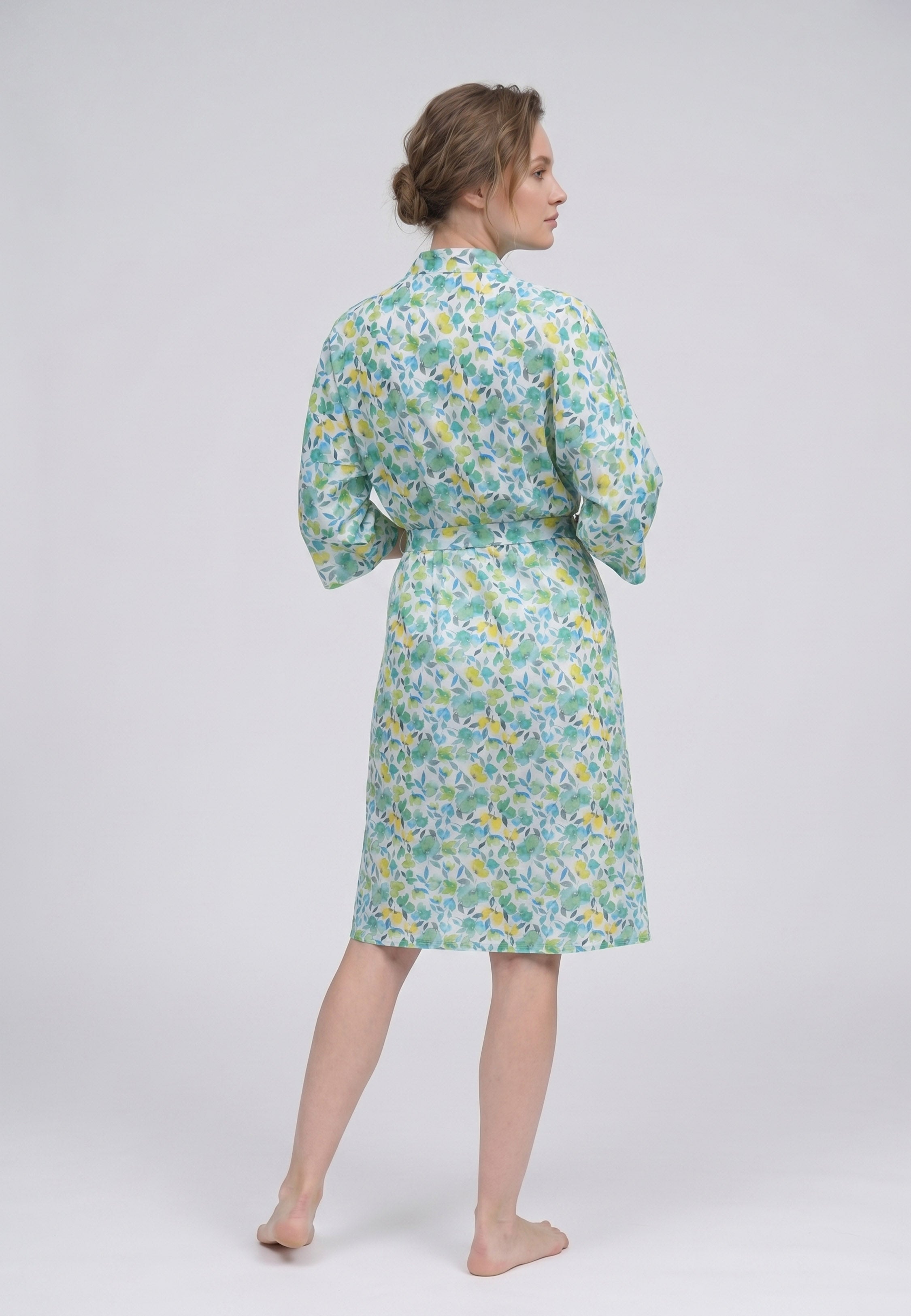 Femme portant un peignoir kimono midi croisé manches évasées imprimé aquarelle abstrait multicolore vert et rose avec ceinture Rosabella Soft Embrace