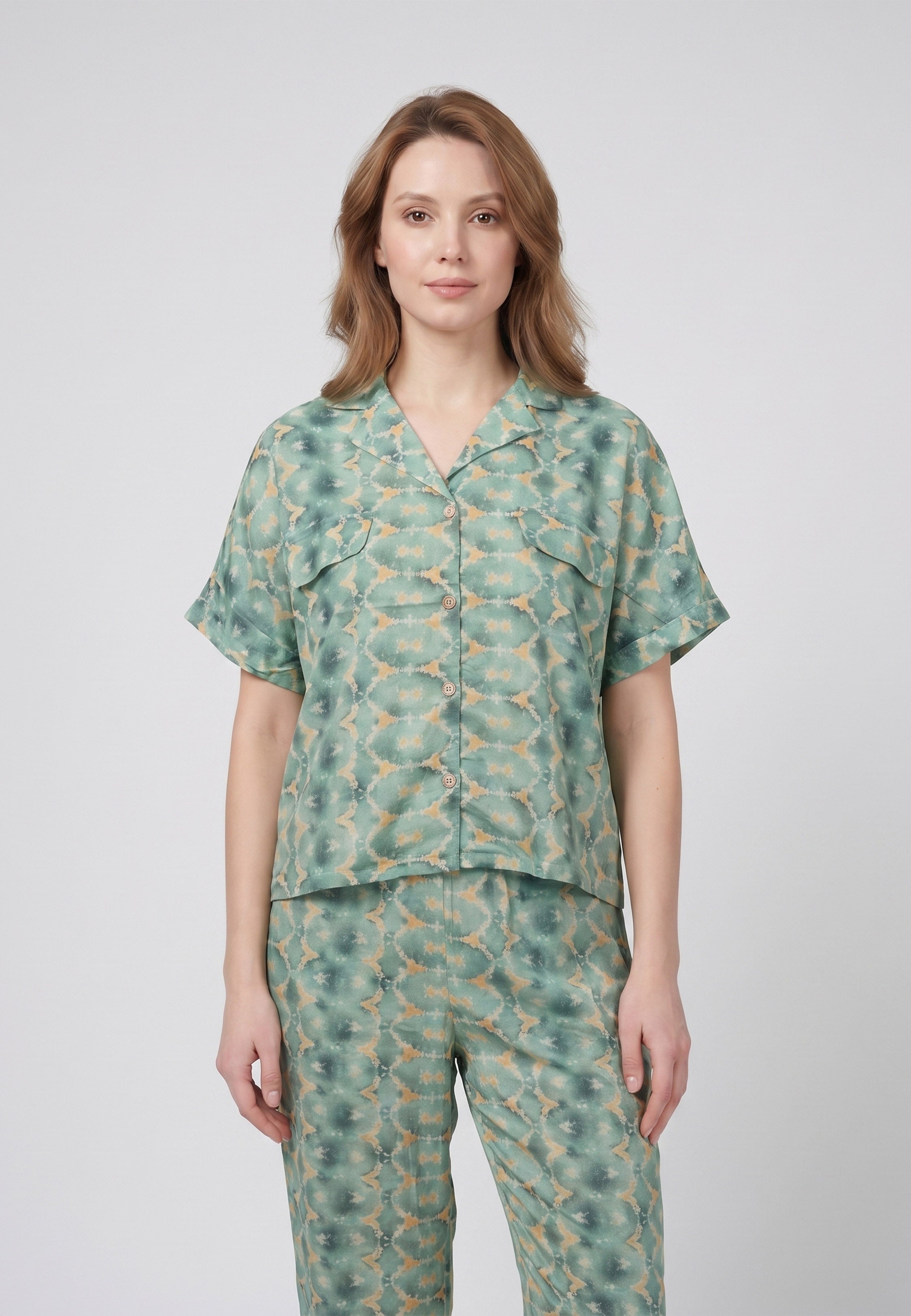 Femme portant un pyjama deux pièces chemise boutonnée col revers imprimé fleuri aquarelle vert et pantalon long assorti Rosabella Cozy Comforts