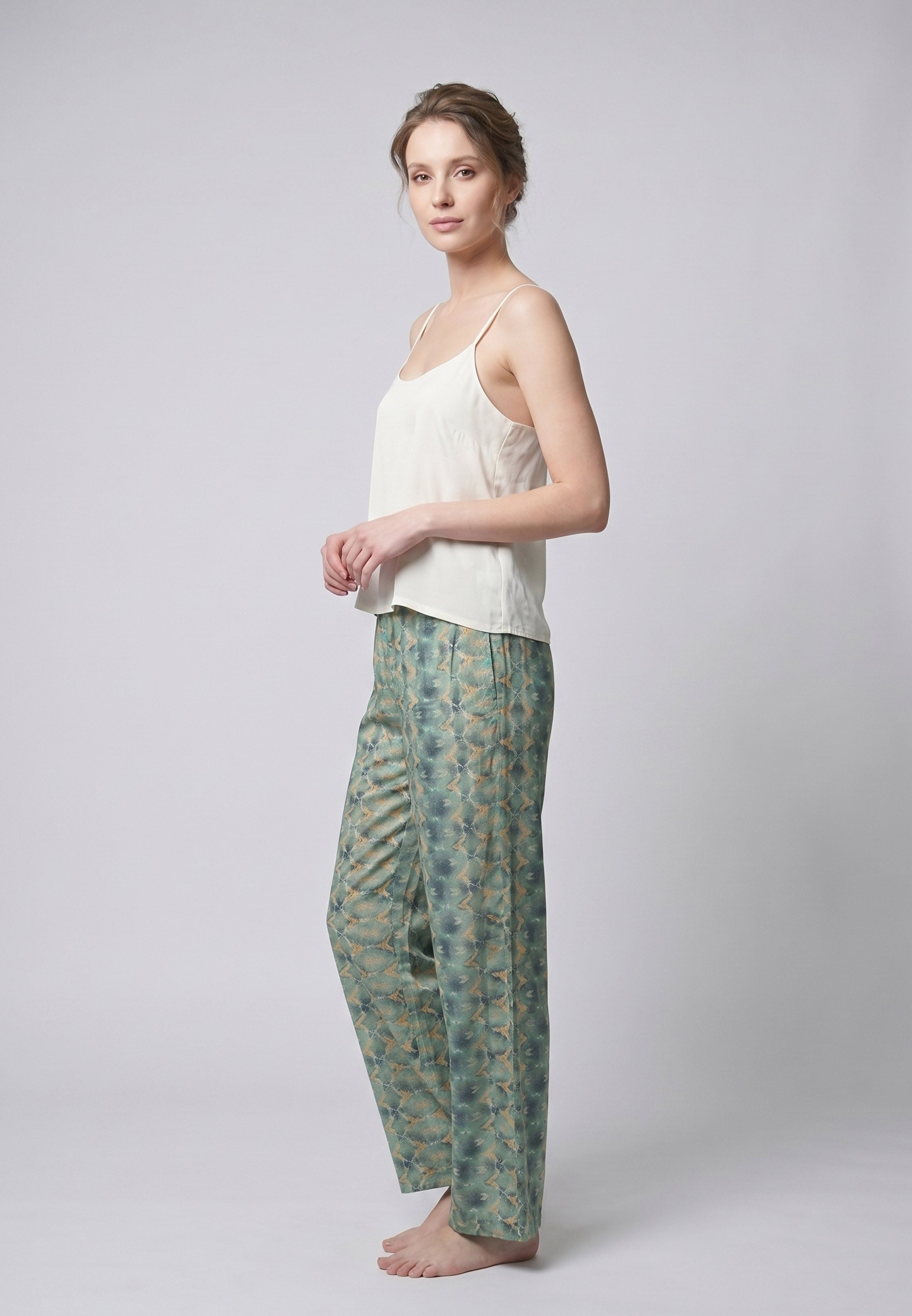 Femme portant un pyjama deux pièces débardeur bretelles fines uni ivoire et pantalon large imprimé fleuri aquarelle vert et blanc Rosabella Cozy Comforts
