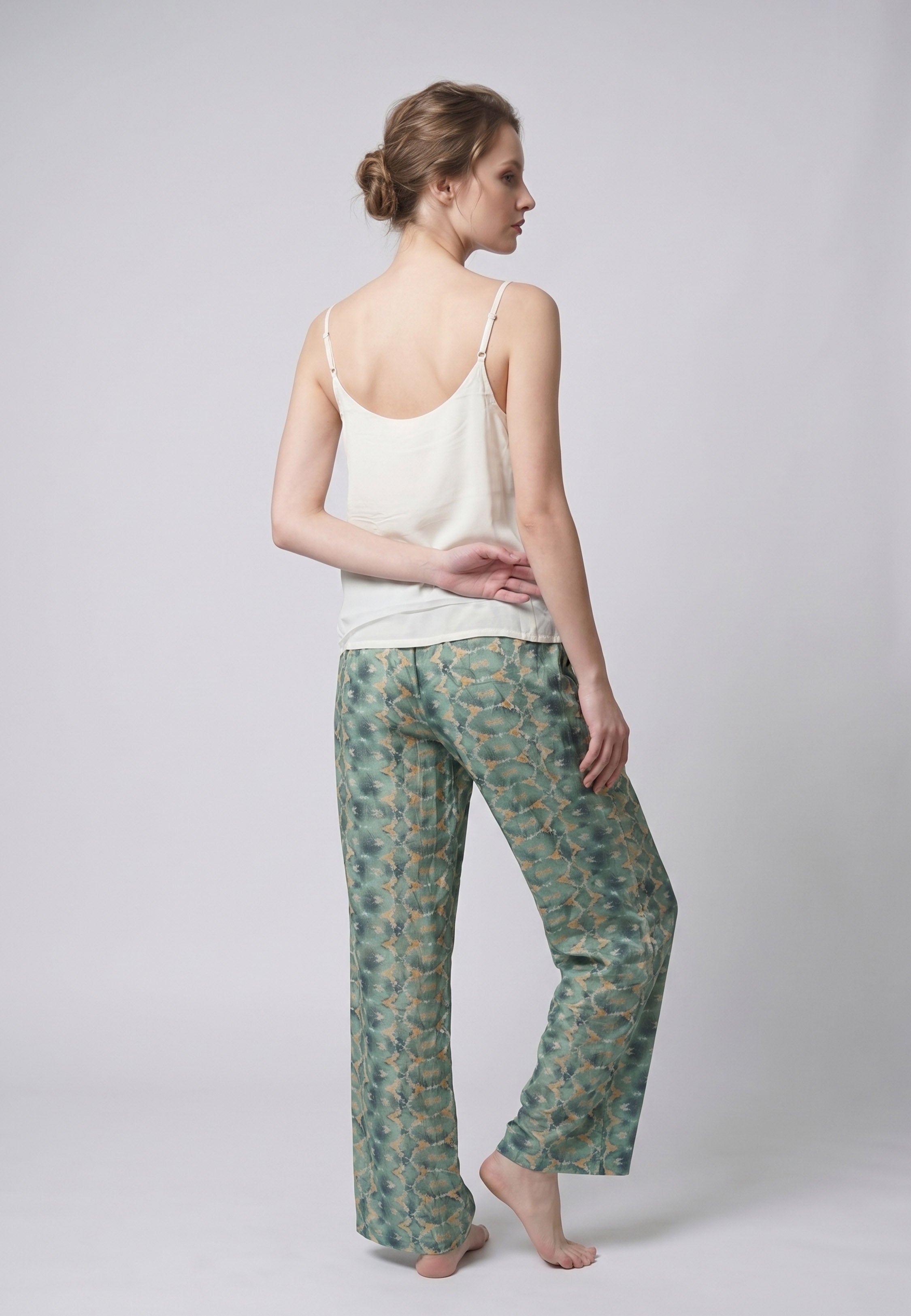 Femme portant un pyjama deux pièces débardeur bretelles fines uni ivoire et pantalon large imprimé fleuri aquarelle vert et blanc Rosabella Cozy Comforts