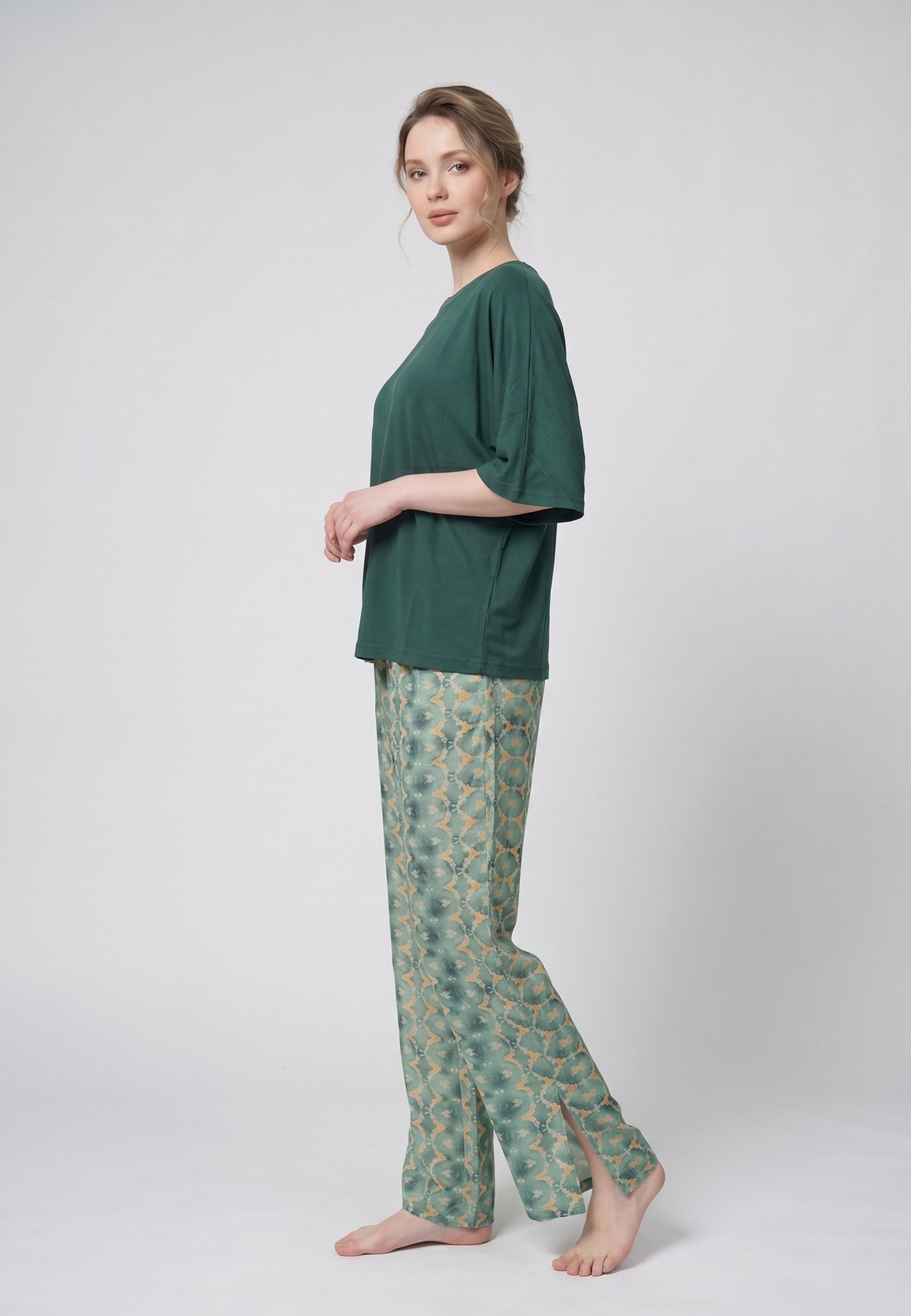 Femme portant un pyjama deux pièces t-shirt oversize uni vert et pantalon large imprimé fleuri blanc sur fond vert Rosabella Cozy Comforts