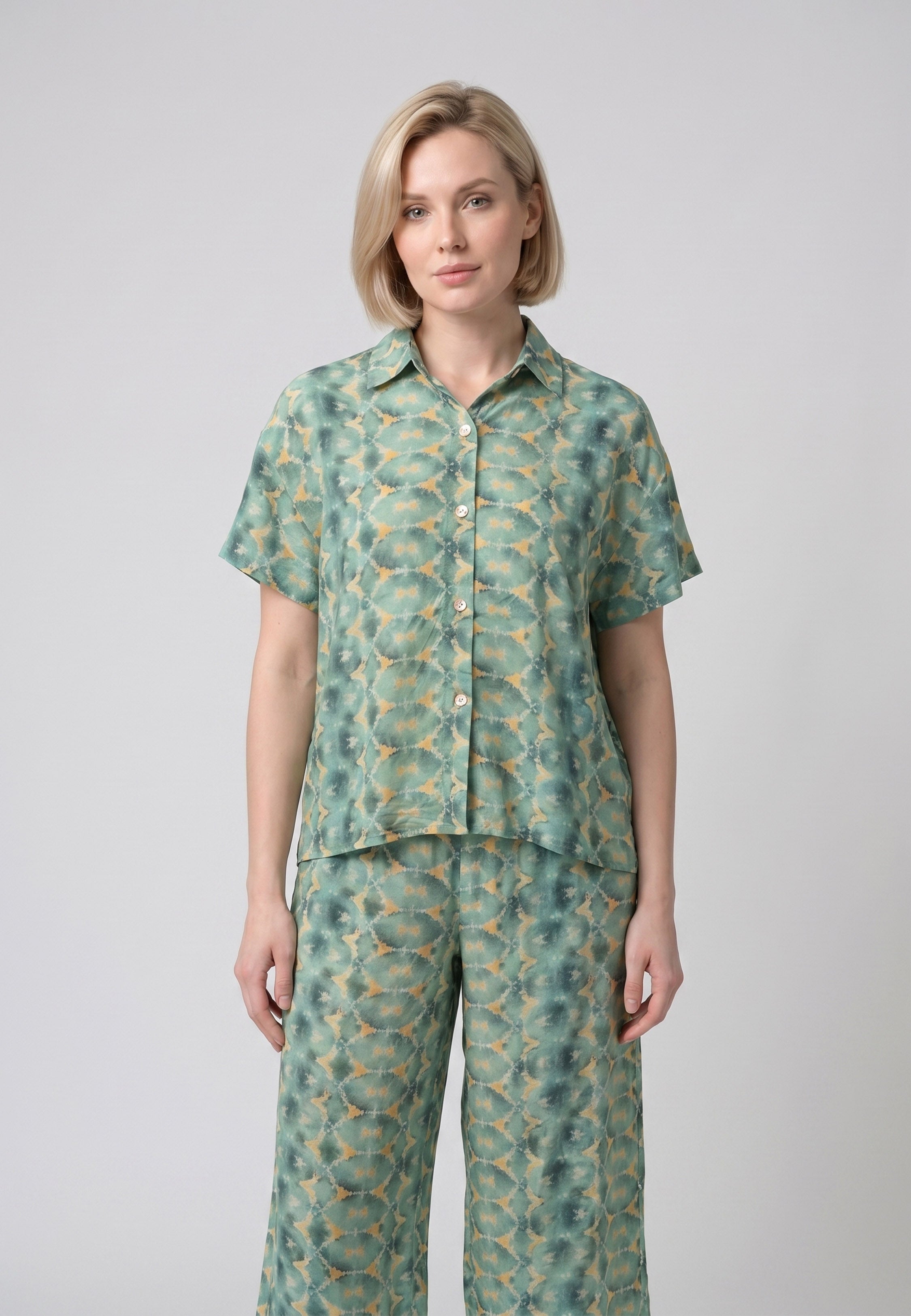 Femme portant un pyjama deux pièces chemise boutonnée col revers imprimé géométrique vert et beige et pantacourt assorti Rosabella Florida