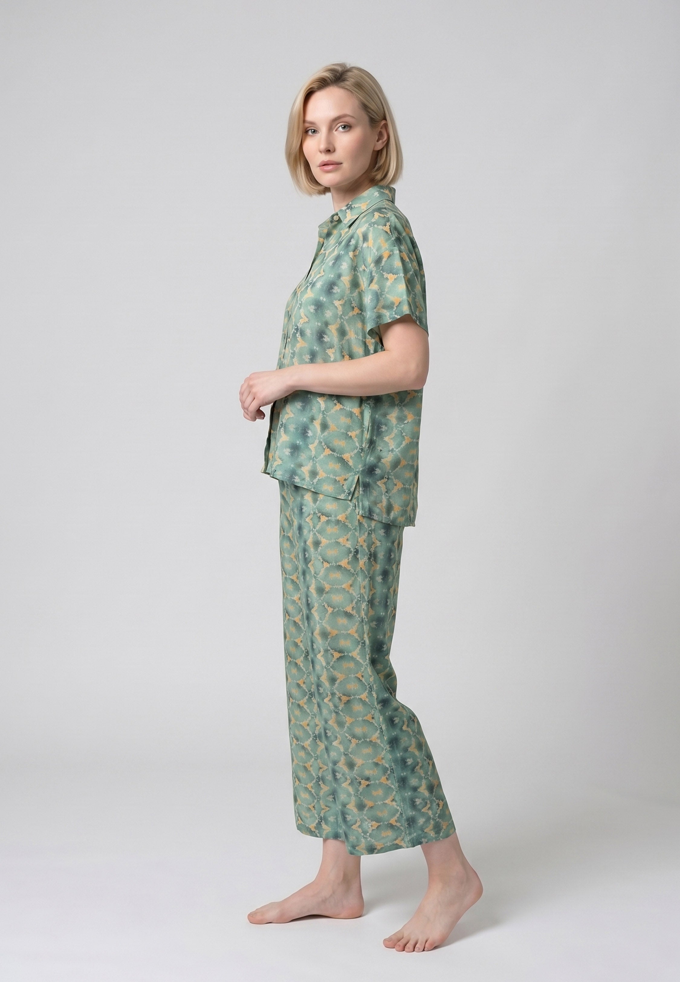 Femme portant un pyjama deux pièces chemise boutonnée col revers imprimé géométrique vert et beige et pantacourt assorti Rosabella Florida