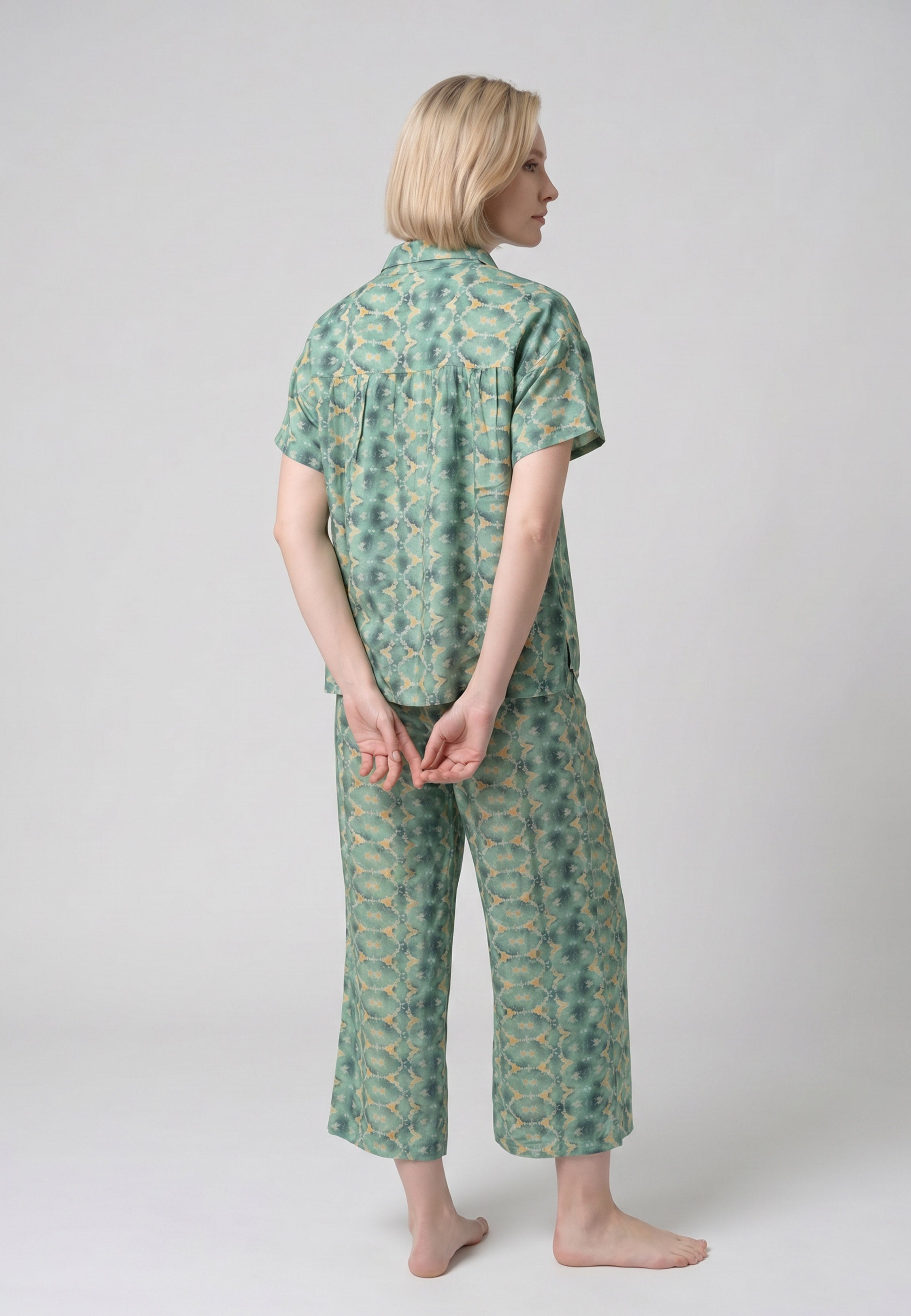 Femme portant un pyjama deux pièces chemise boutonnée col revers imprimé géométrique vert et beige et pantacourt assorti Rosabella Florida
