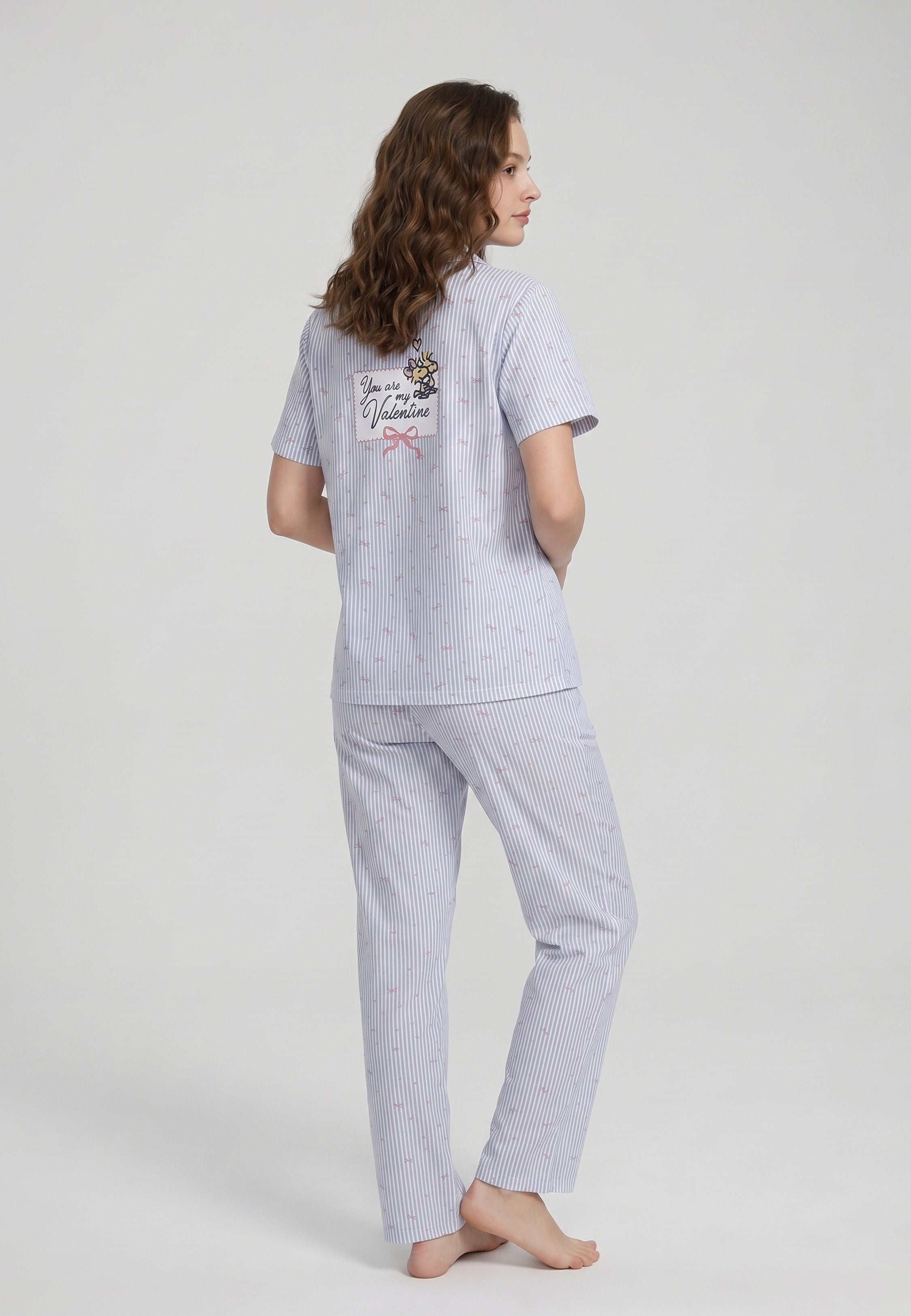 Femme portant un pyjama deux pièces chemise boutonnée col pyjama à revers manches courtes imprimé rayé fleuri bleu ciel et blanc badge brodé et pantalon droit assorti Rosabella Lina